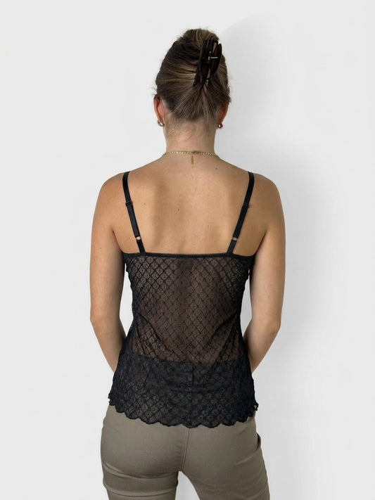 Back view of a black lace top with scalloped hem and adjustable straps.