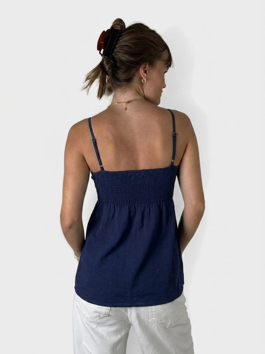 Back view of a navy blue top with smocked detail.