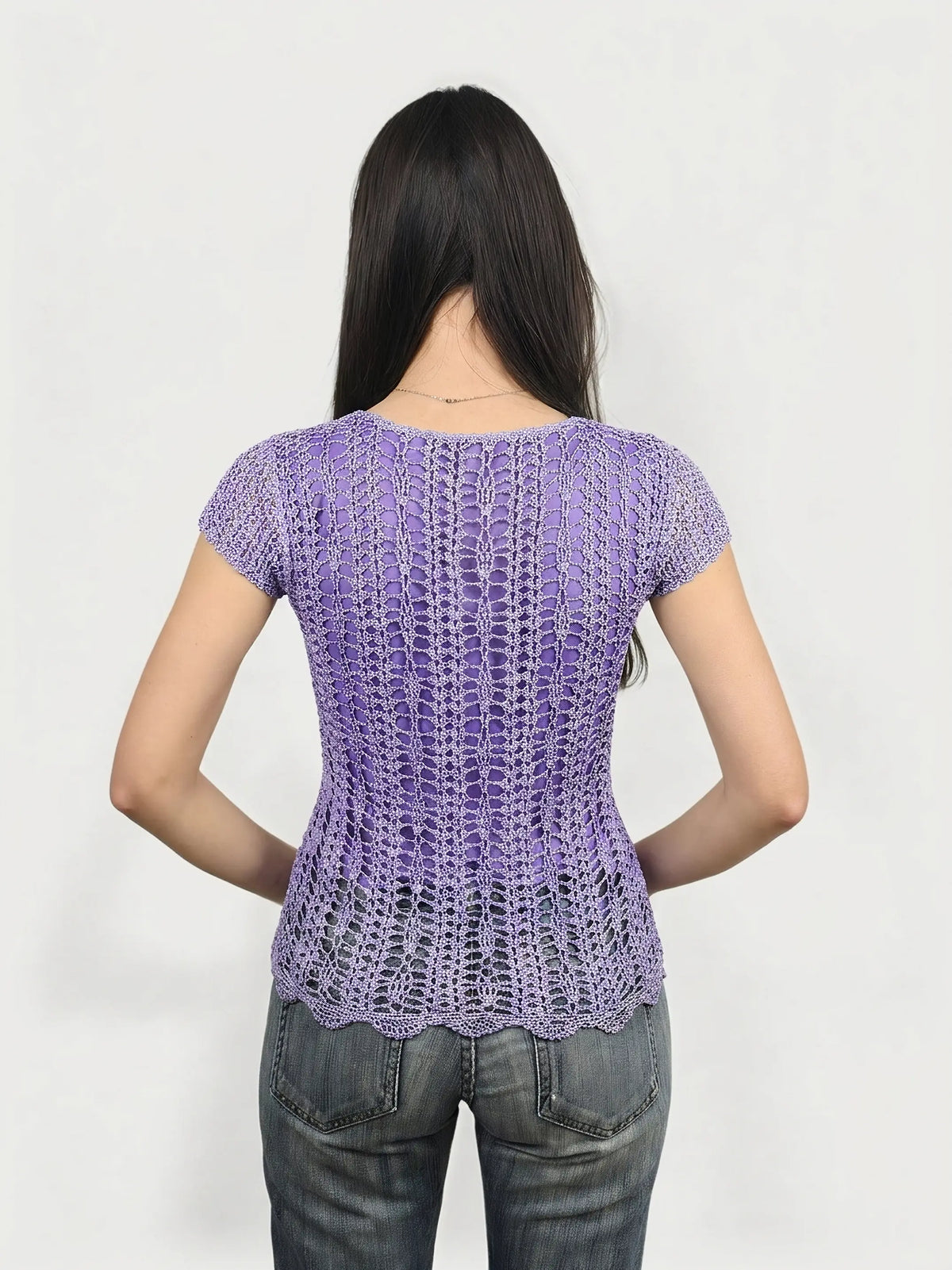 Back view of a purple crocheted women's top featuring a scalloped hem.