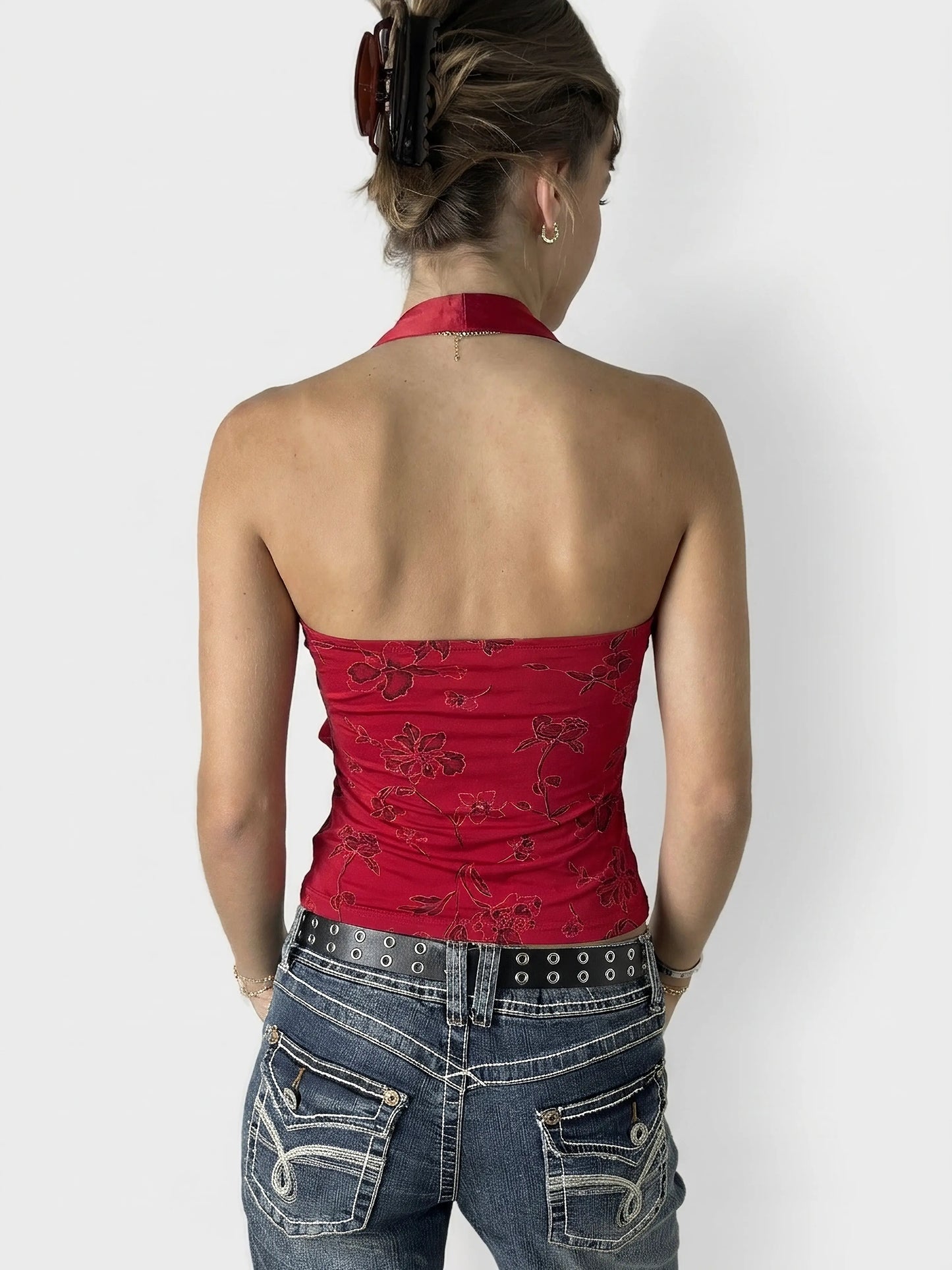 Back view of a red floral print halter neck top.