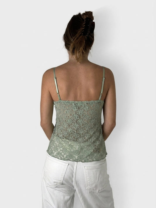 Back view of a green lace camisole top with thin straps.