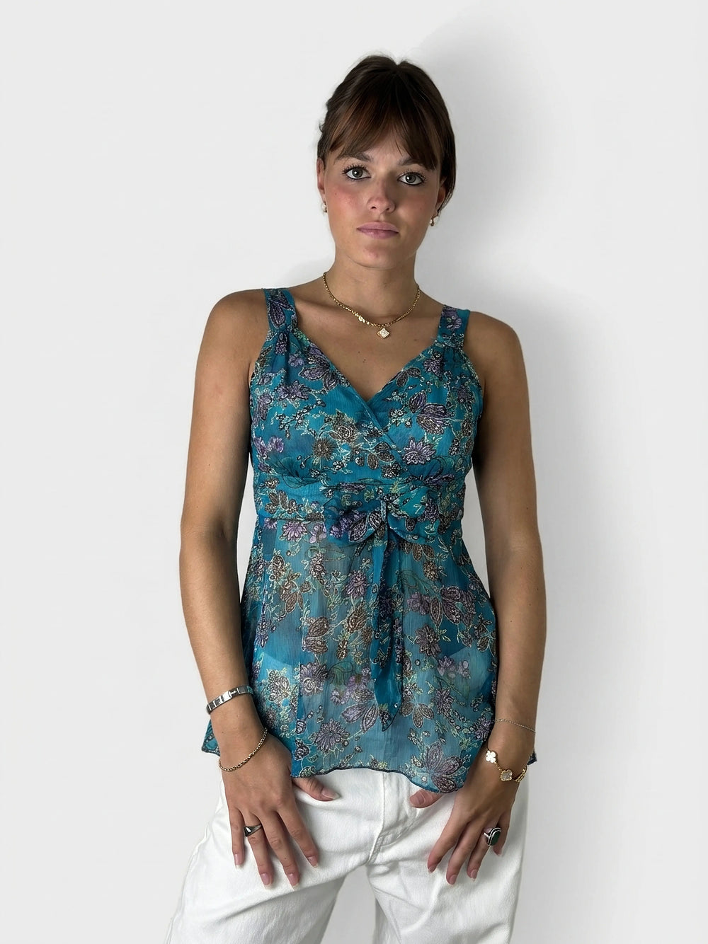 Front view of a women's teal floral upper body top with tie detail.