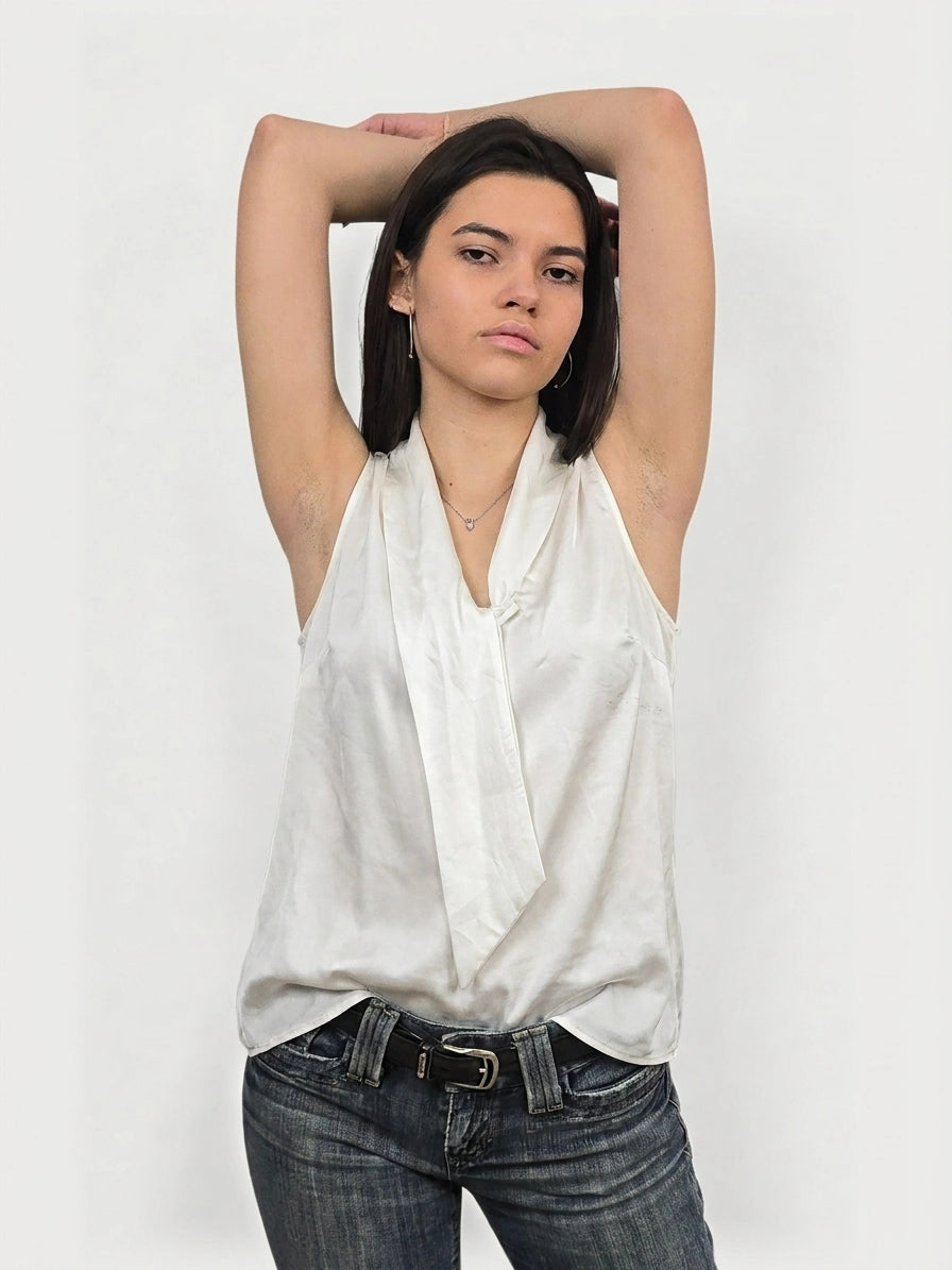 Front view of a white sleeveless top with a draped neckline.
