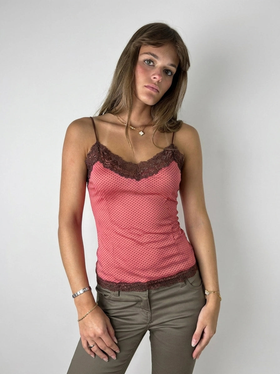 Front view of a pink polka dot top with brown lace trim.