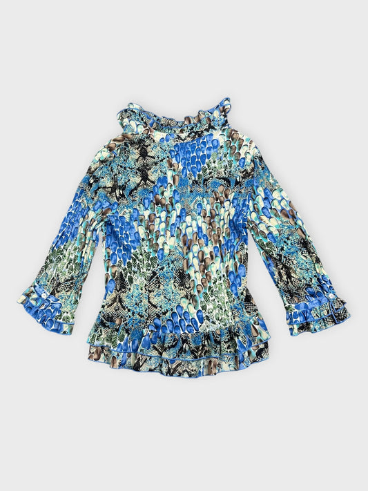 Back view of a blue patterned blouse with ruffled collar and sleeves.