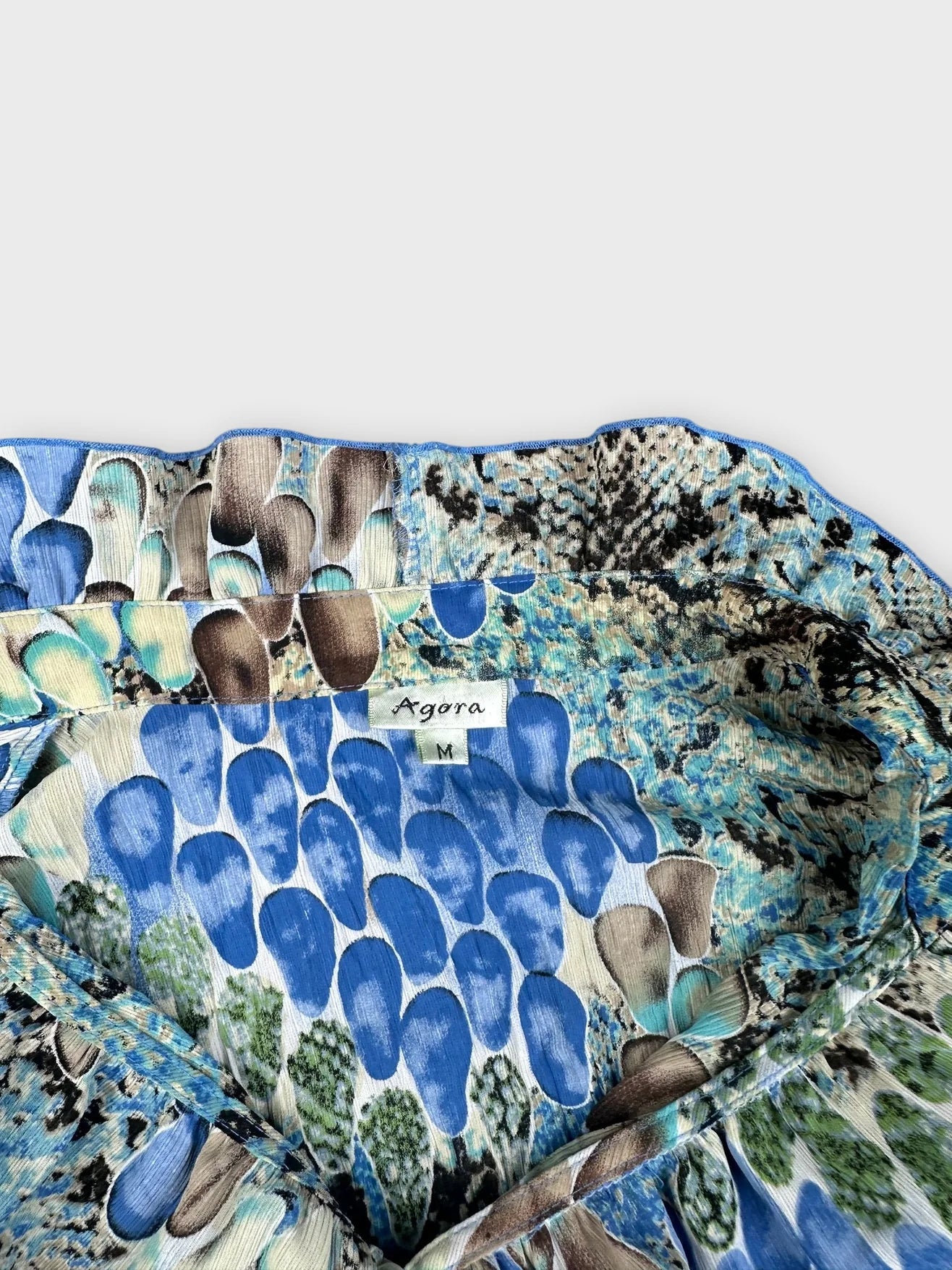Detail view of a vintage blue patterned Agora Blossom Top with a soft neckline.