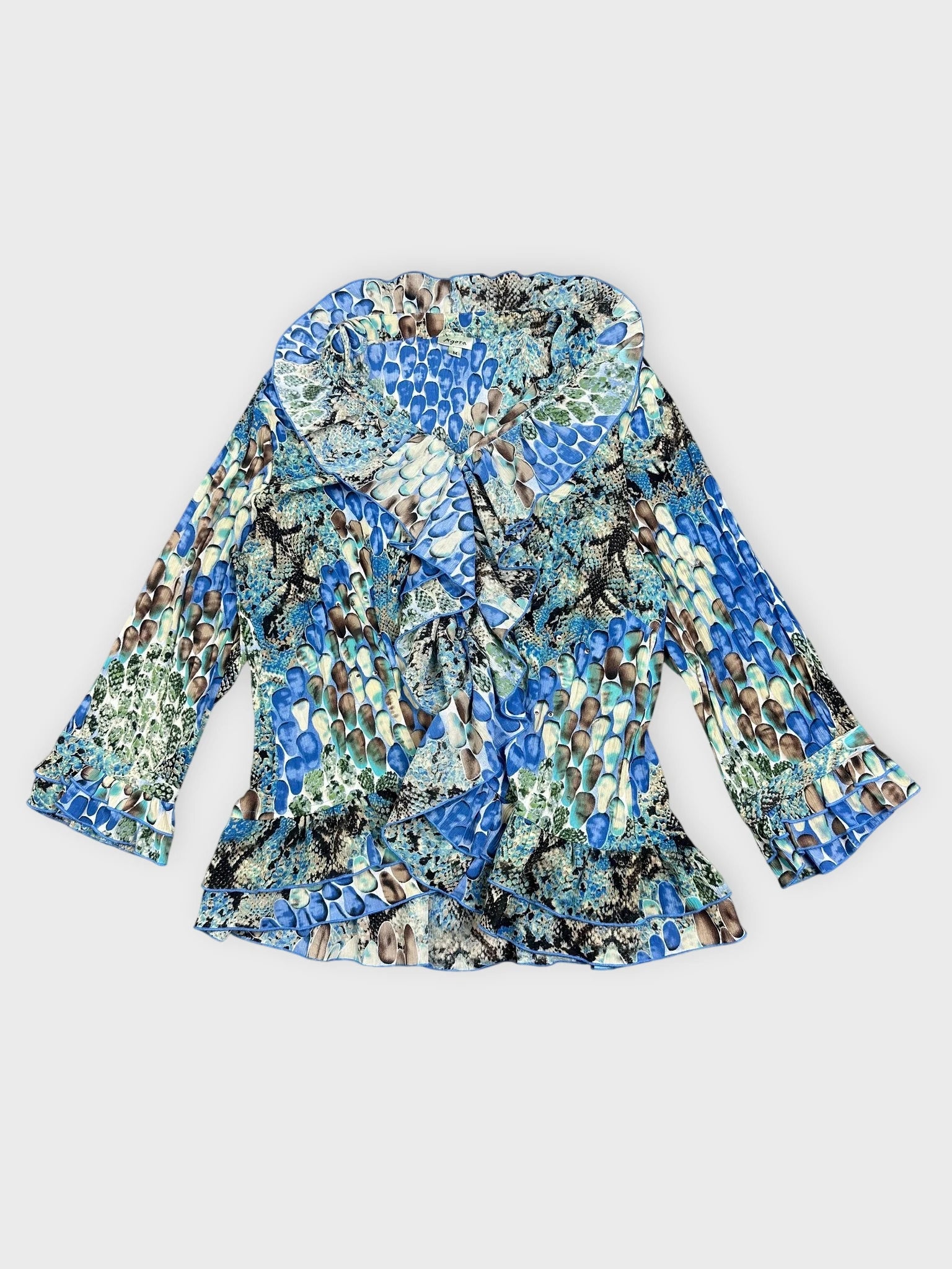 Front view of a vintage blue patterned blouse with ruffled trim.