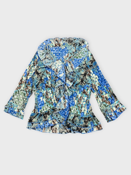 Front view of a vintage blue patterned blouse with ruffled trim.