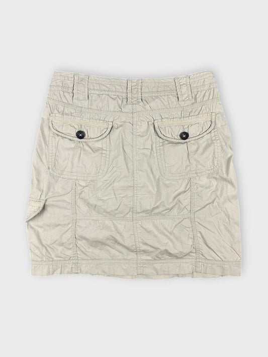 Beige mini skirt with side pockets back view showing button details.