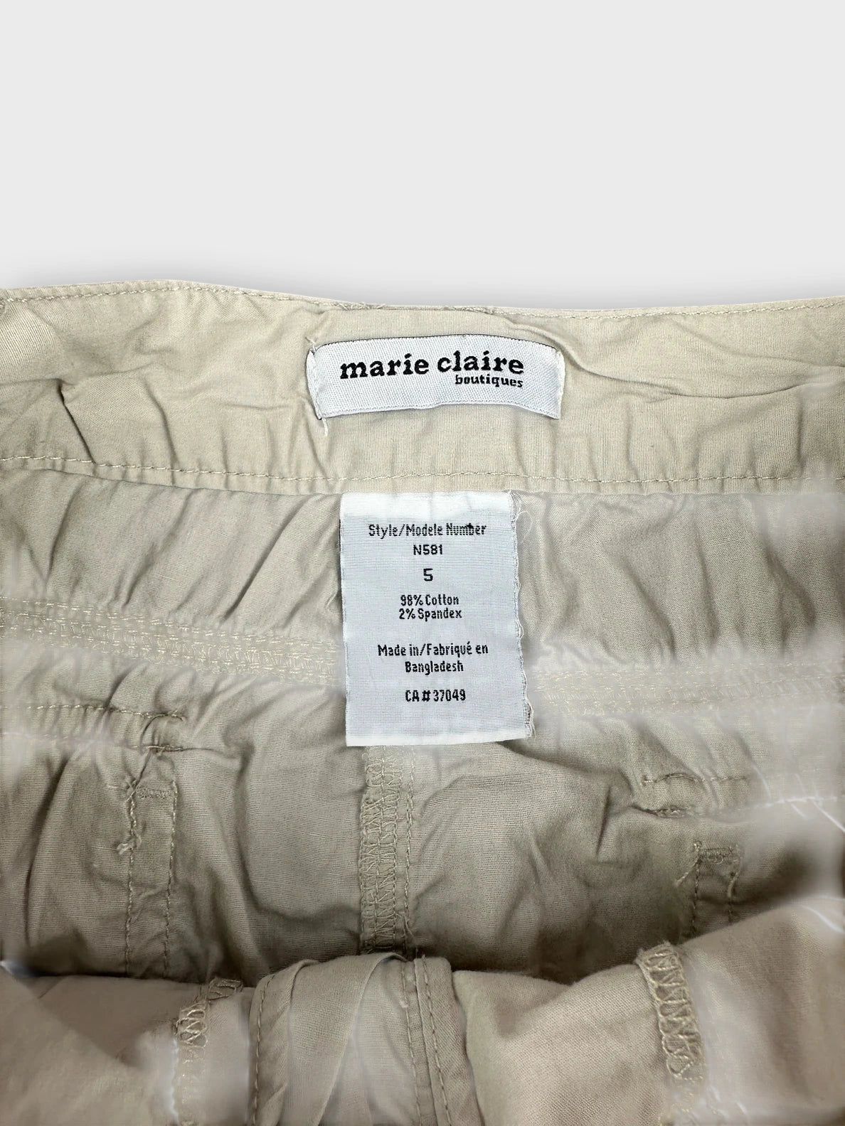 Beige mini skirt detail view featuring inner label and stitching.