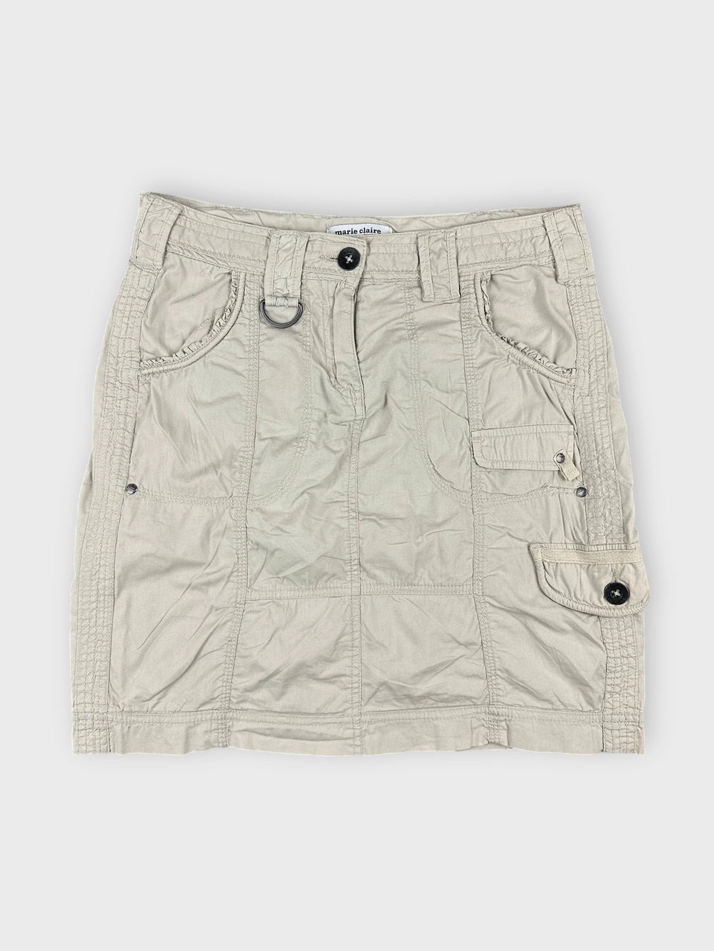 Beige mini skirt with side pockets front view featuring a button closure and textured fabric.