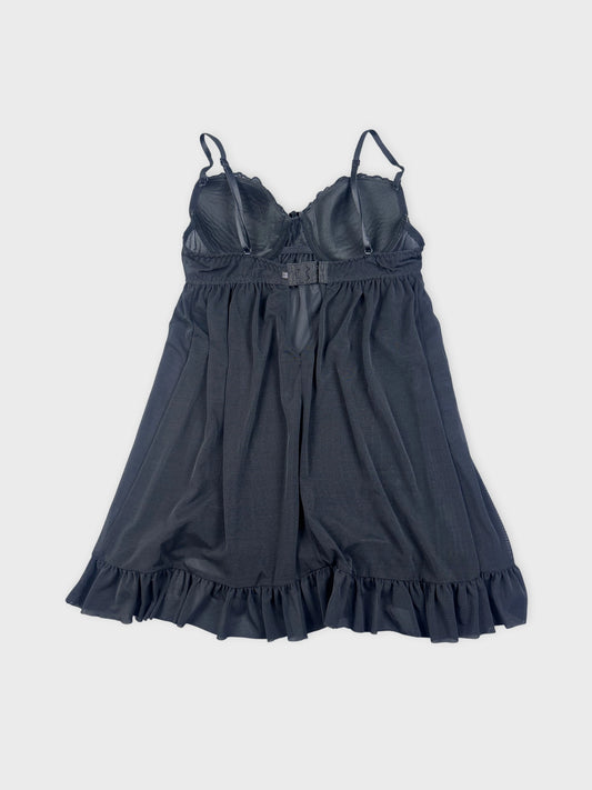 Back view of a black camisole with a ruffled hemline.