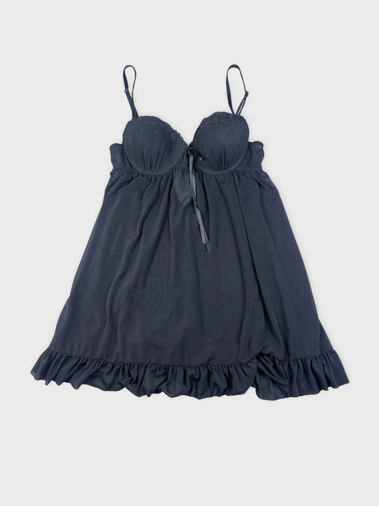 Black camisole with ruffled hem displayed in front view.