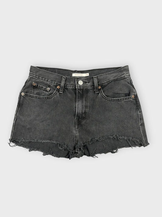 Black denim mini shorts with distressed hem front view.