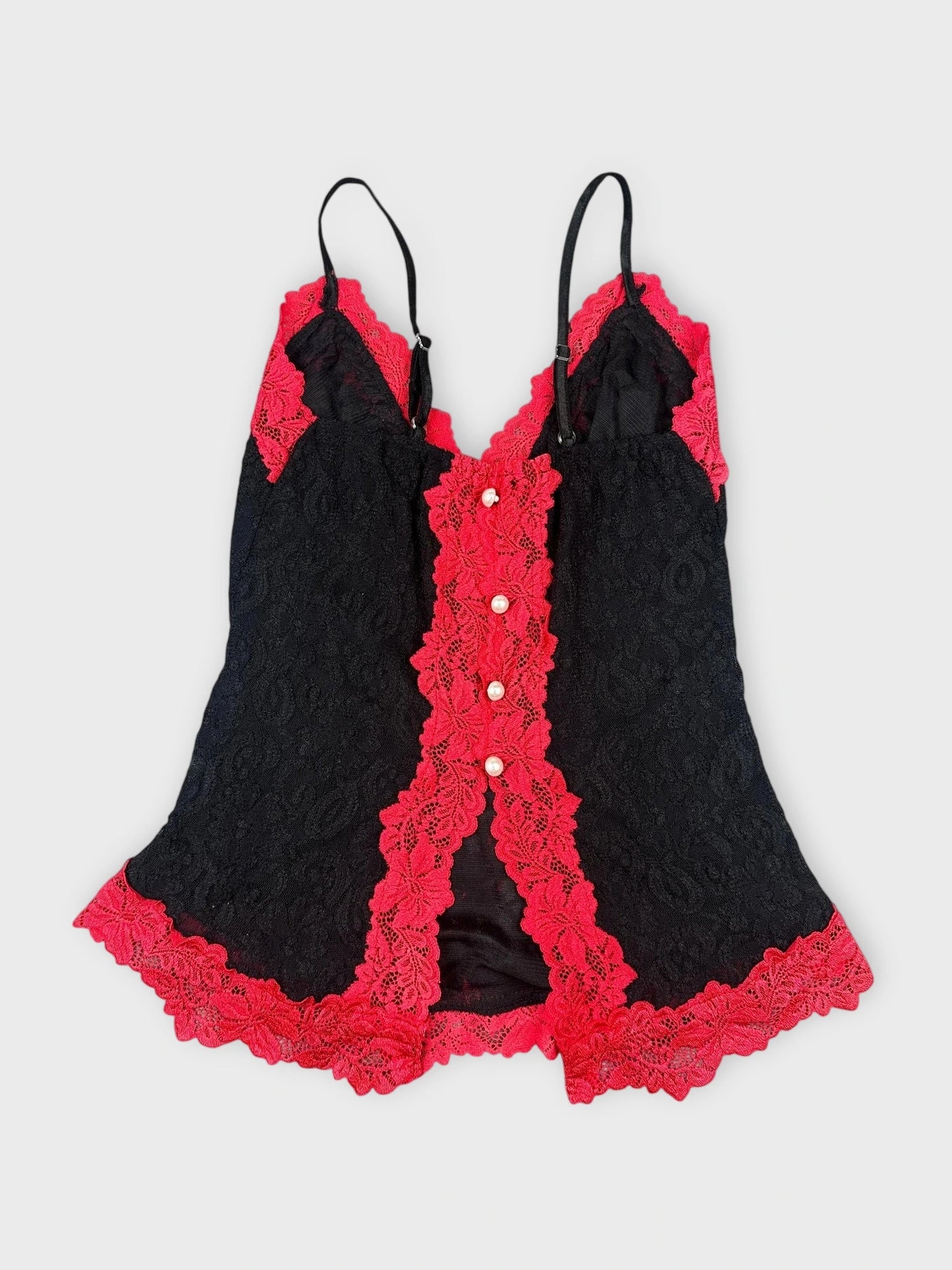 Back view of black lace crop top with red lace trim and pearl buttons.