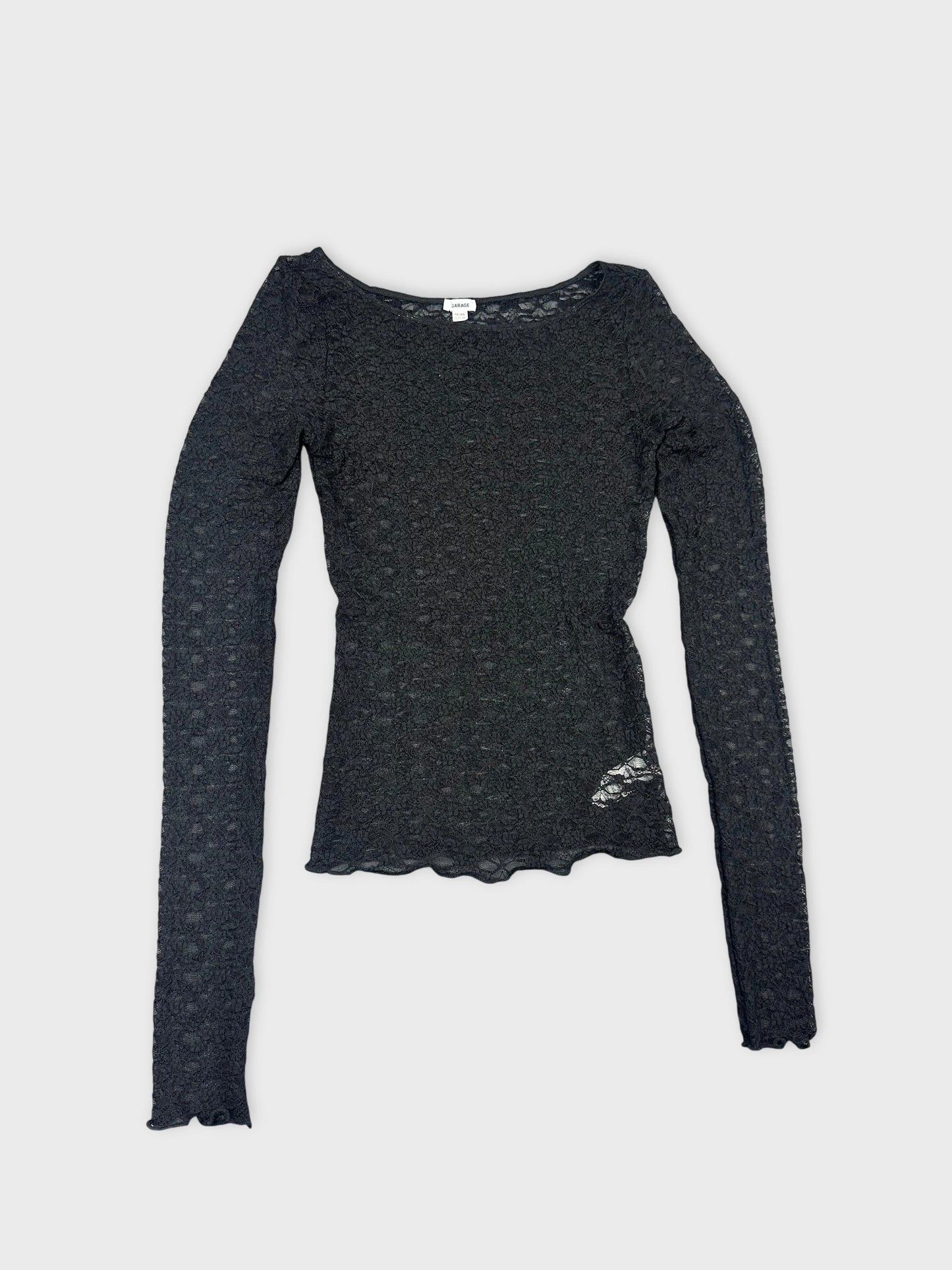 Detail view of a black lace long sleeve top with scalloped hem.