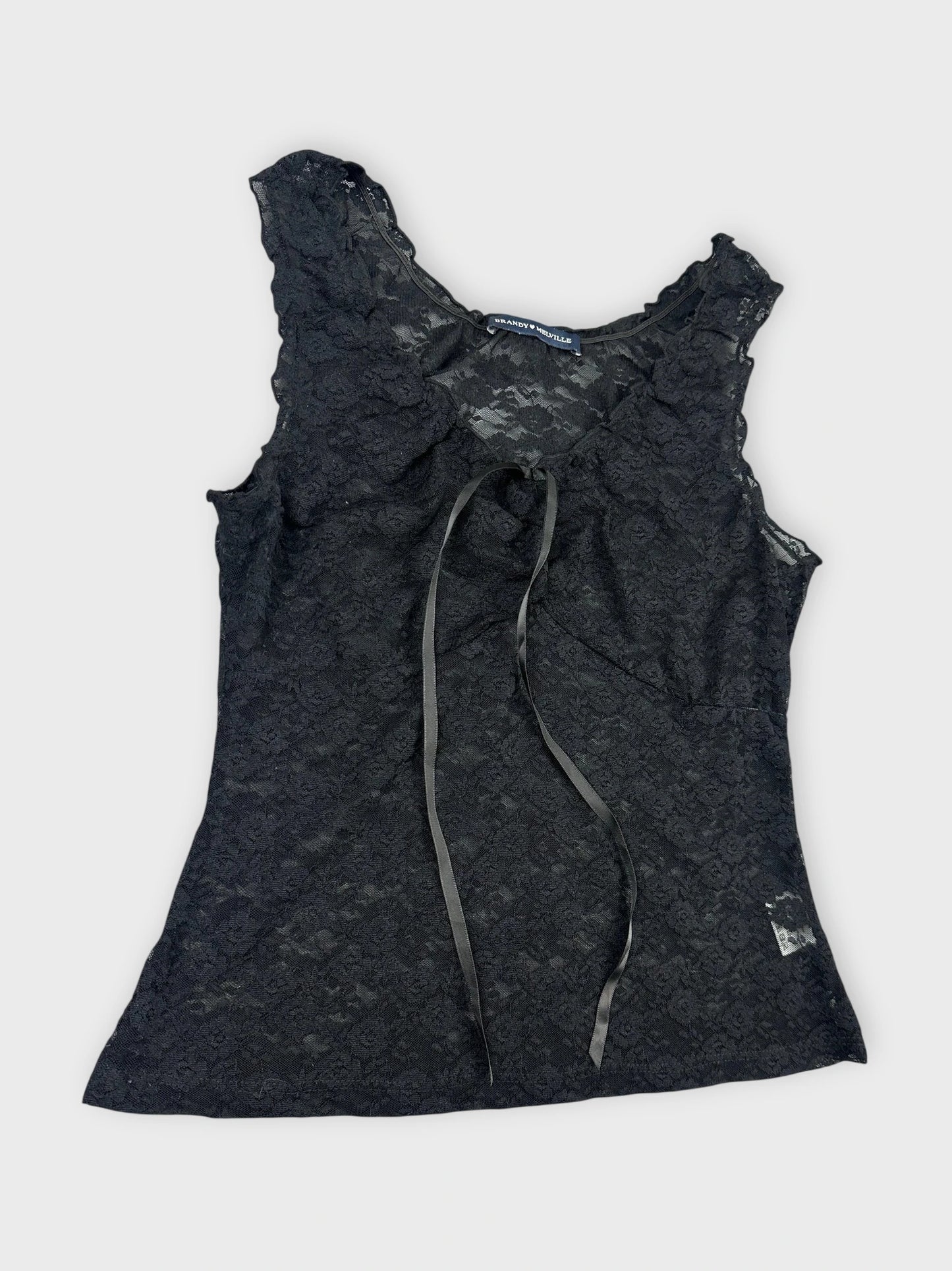 Black lace top detail view featuring floral pattern and ribbon tie.