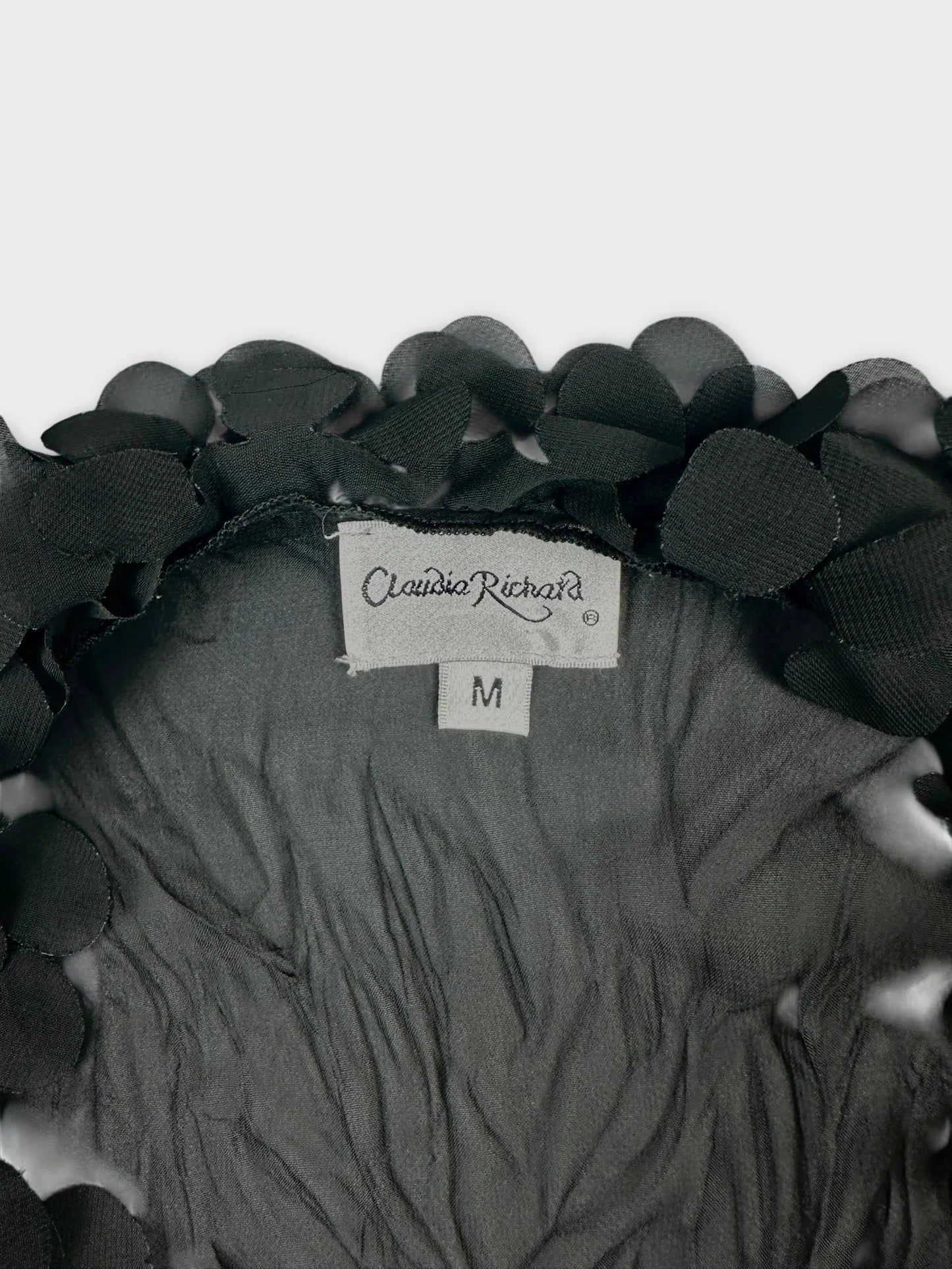 Detail view of a black long sleeve shirt with floral trim