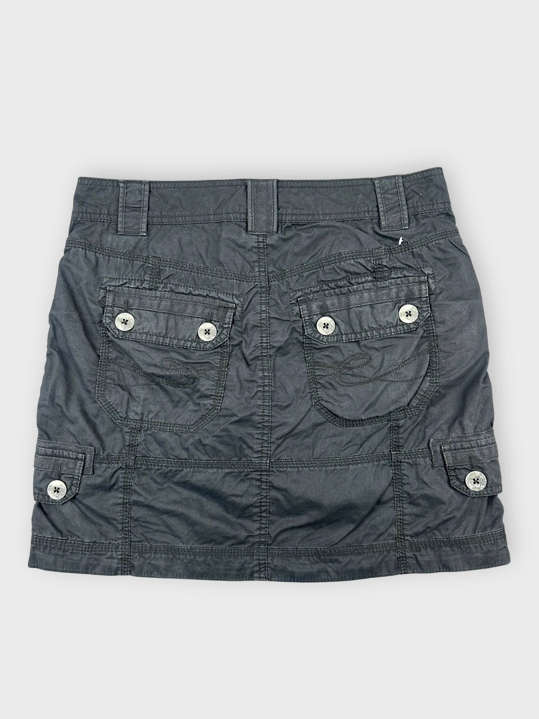 Back view of a black mini skirt with utility pockets and button details.