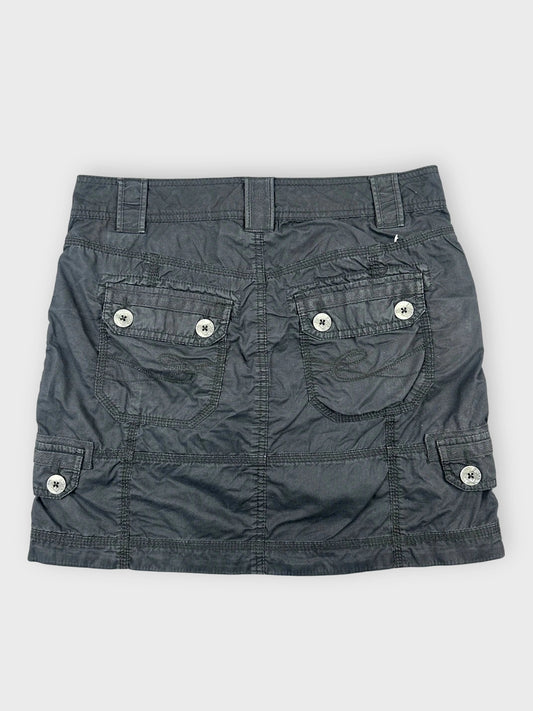 Back view of a black mini skirt with utility pockets and button details.