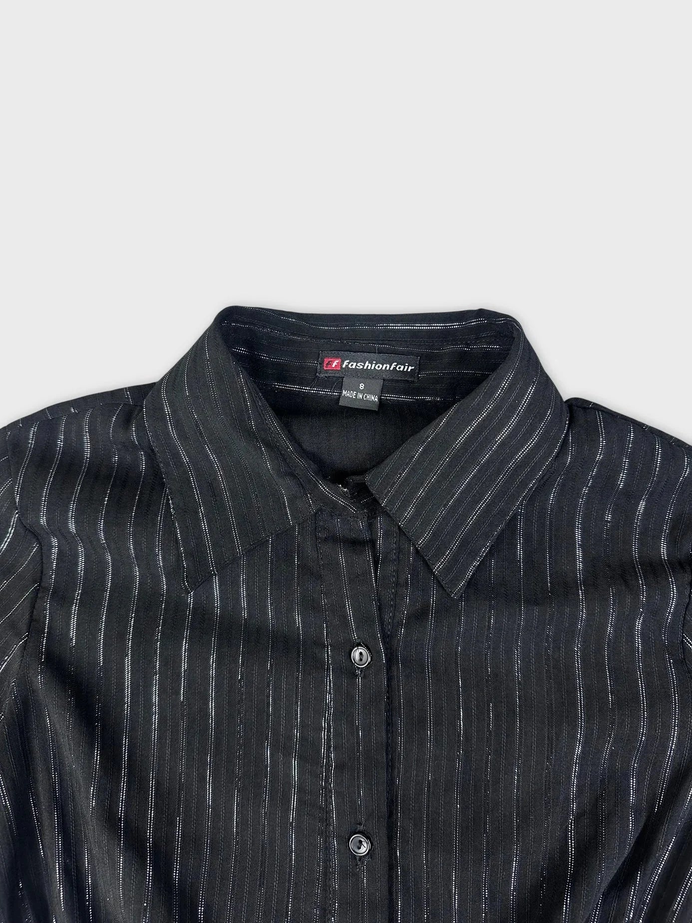Black fitted button-up shirt with shiny pinstripes detail view.