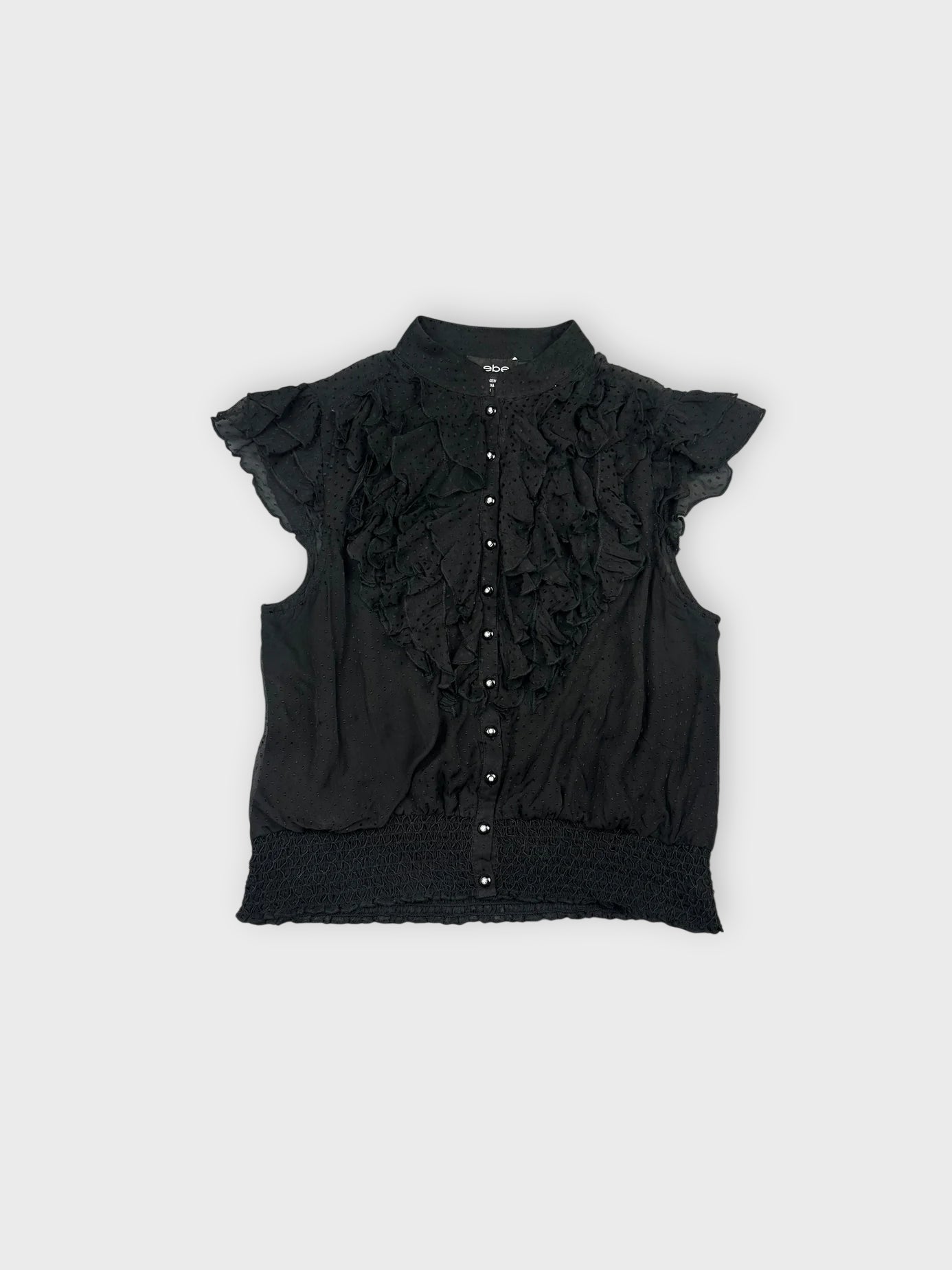 Front view of a black ruffled blouse with button details.
