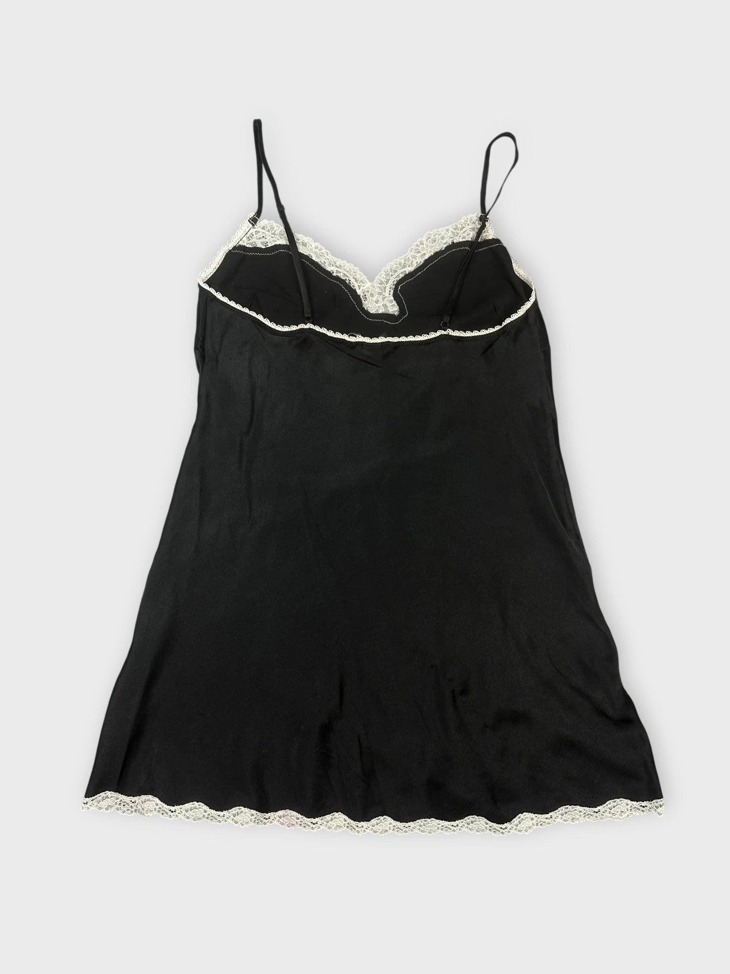 Black satin cami with lace trim, back view, featuring delicate scalloped detail at hem.
