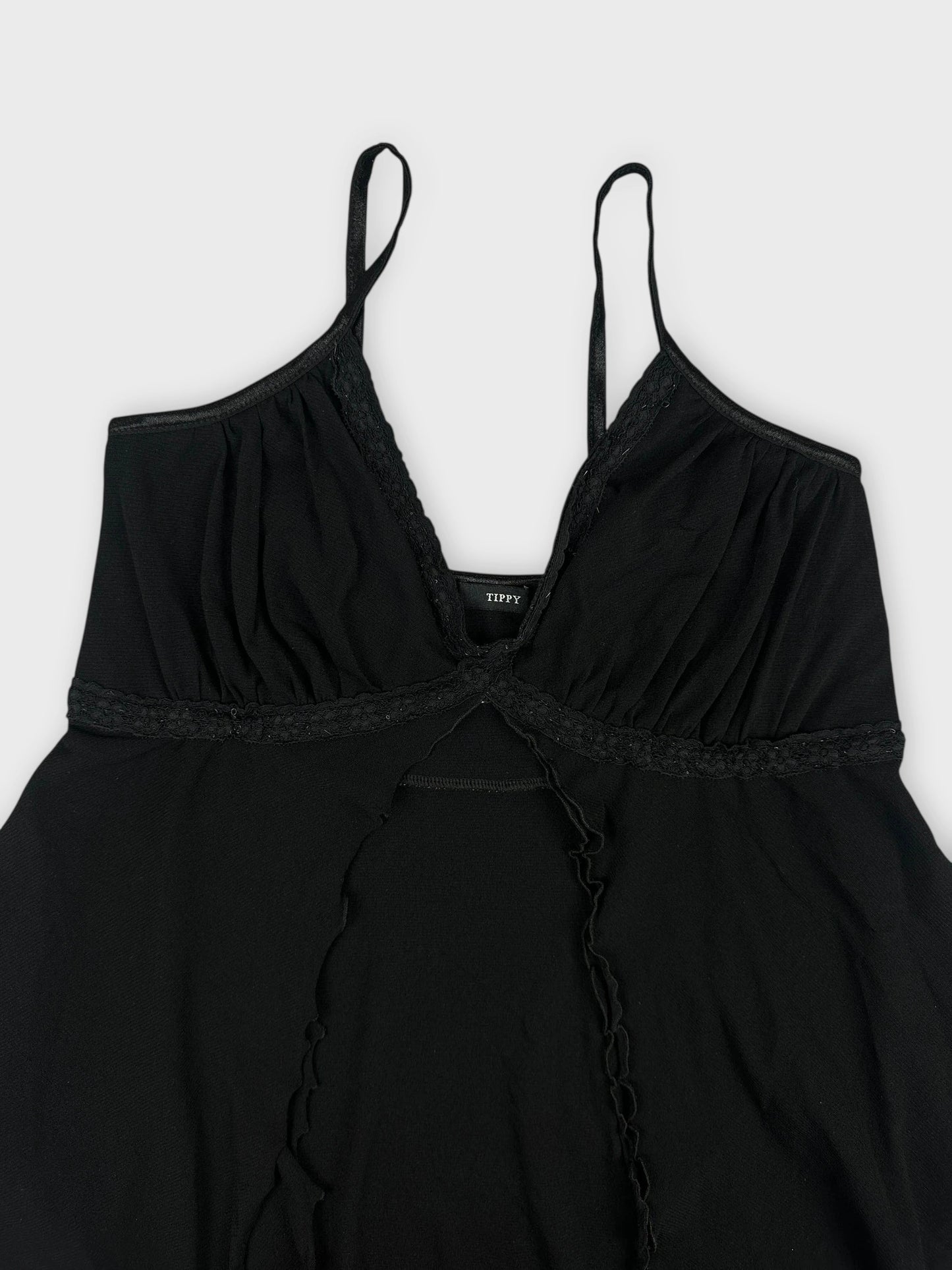 Detail view of black sheer cami top featuring lace trim.