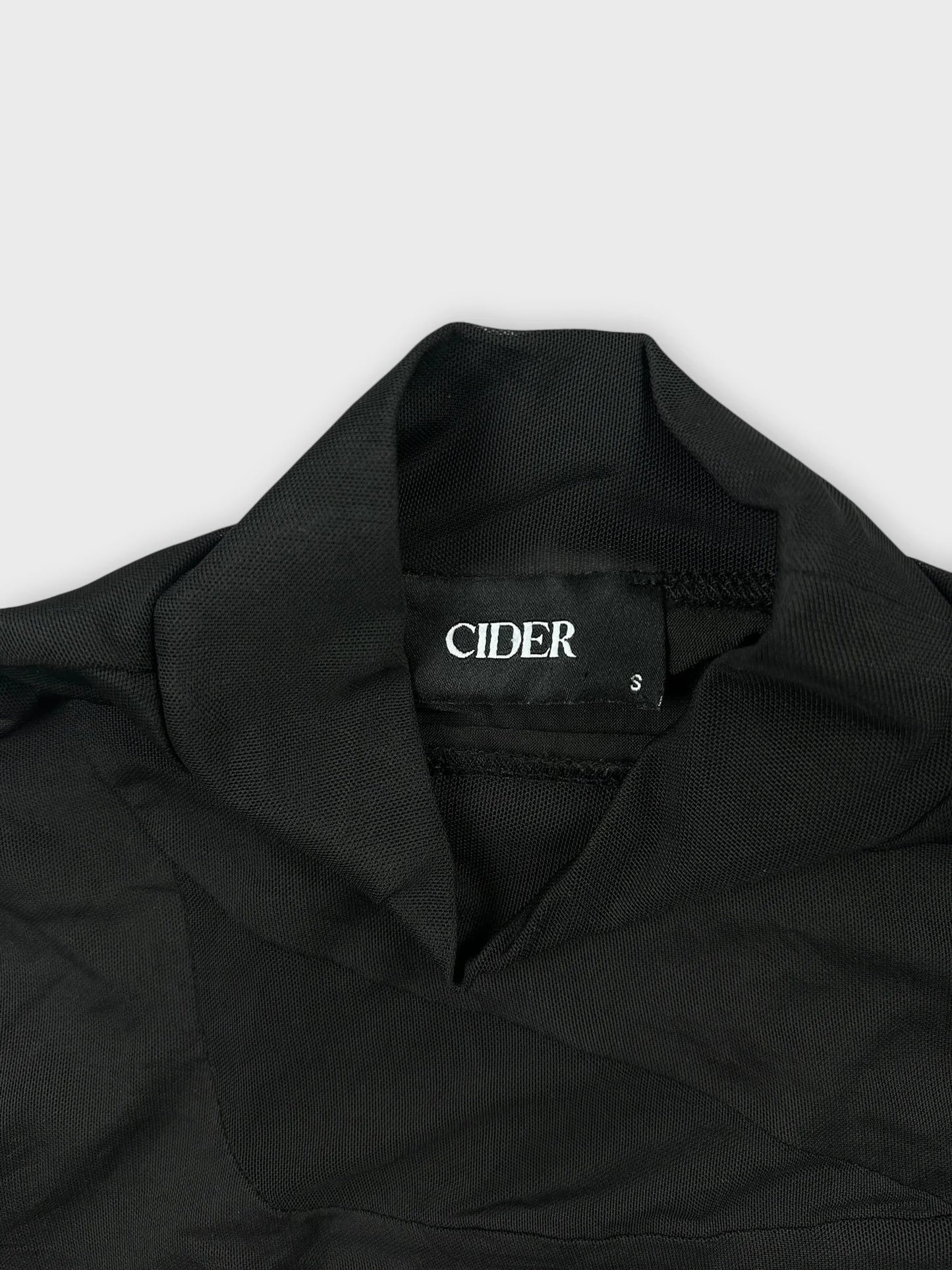 Detail view of black sheer crop top featuring a unique cutout design.