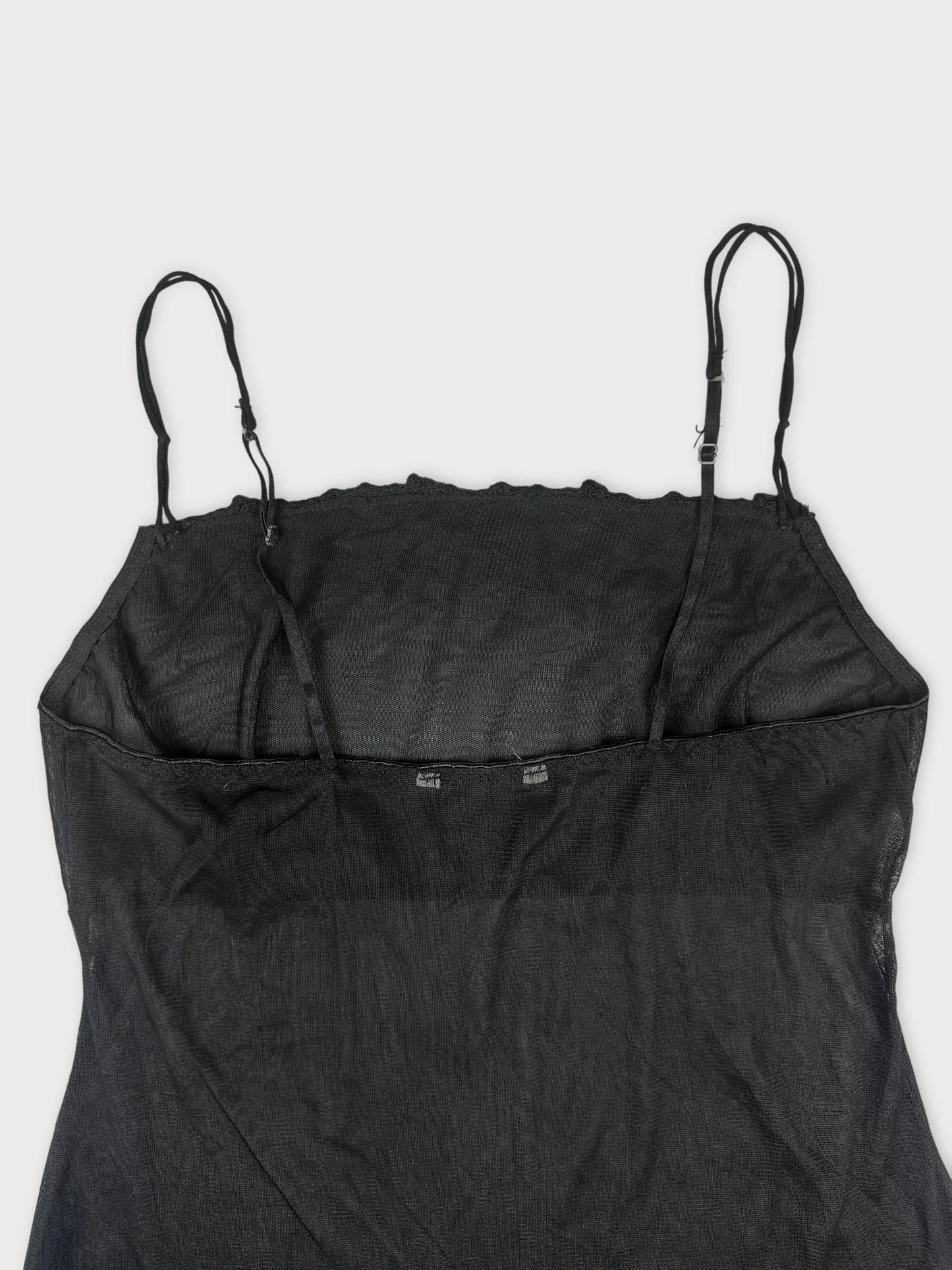 Back view of a black sheer slip dress with spaghetti straps.