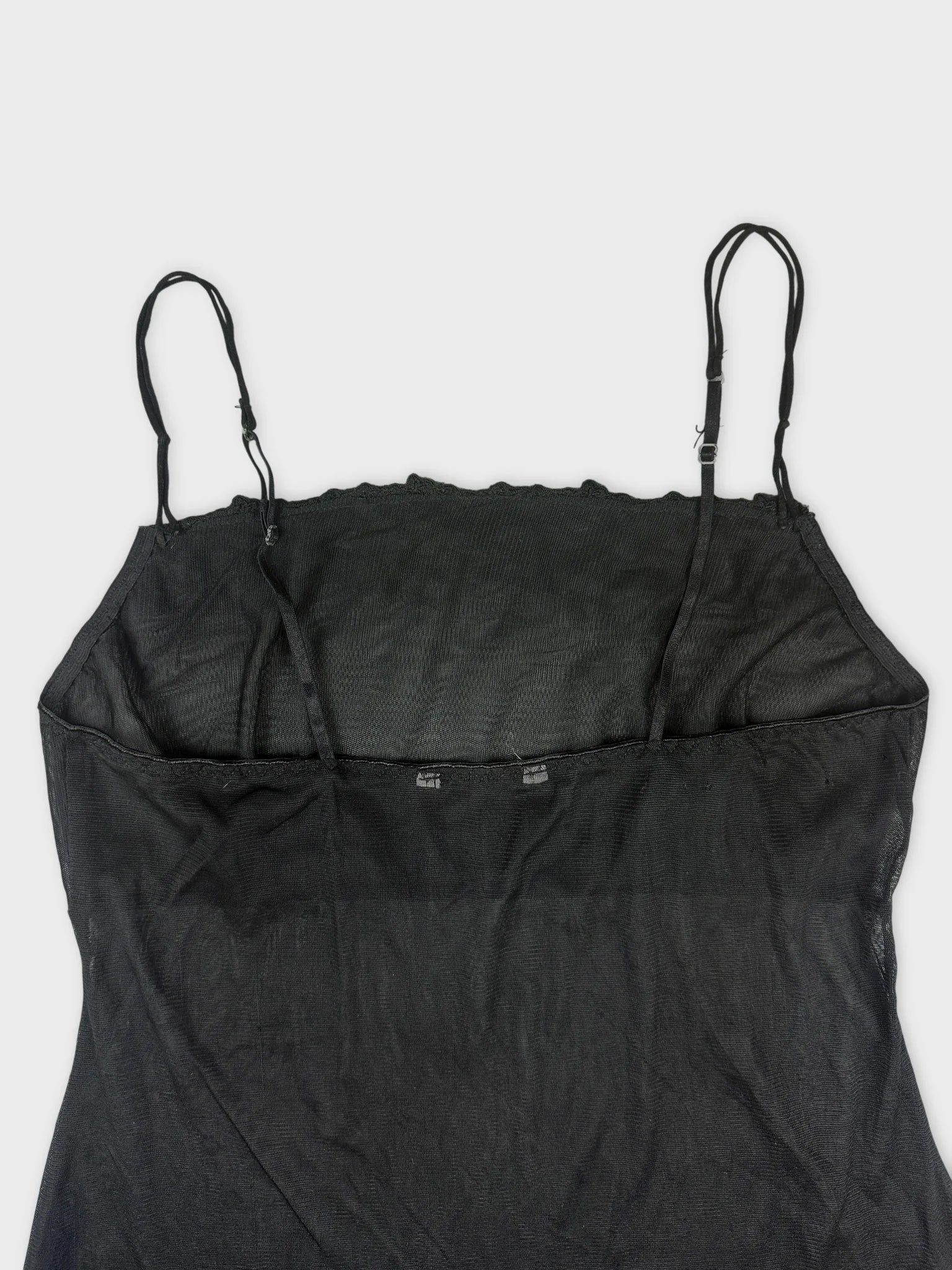 Back view of a black sheer slip dress with spaghetti straps.