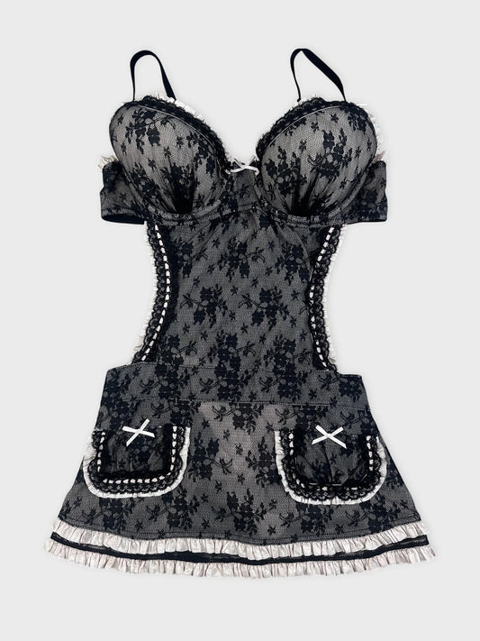 Front view of a black lace top with ruffled straps and pocket detail.