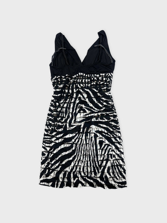 Back view of a black and white striped mini dress with gathered texture.