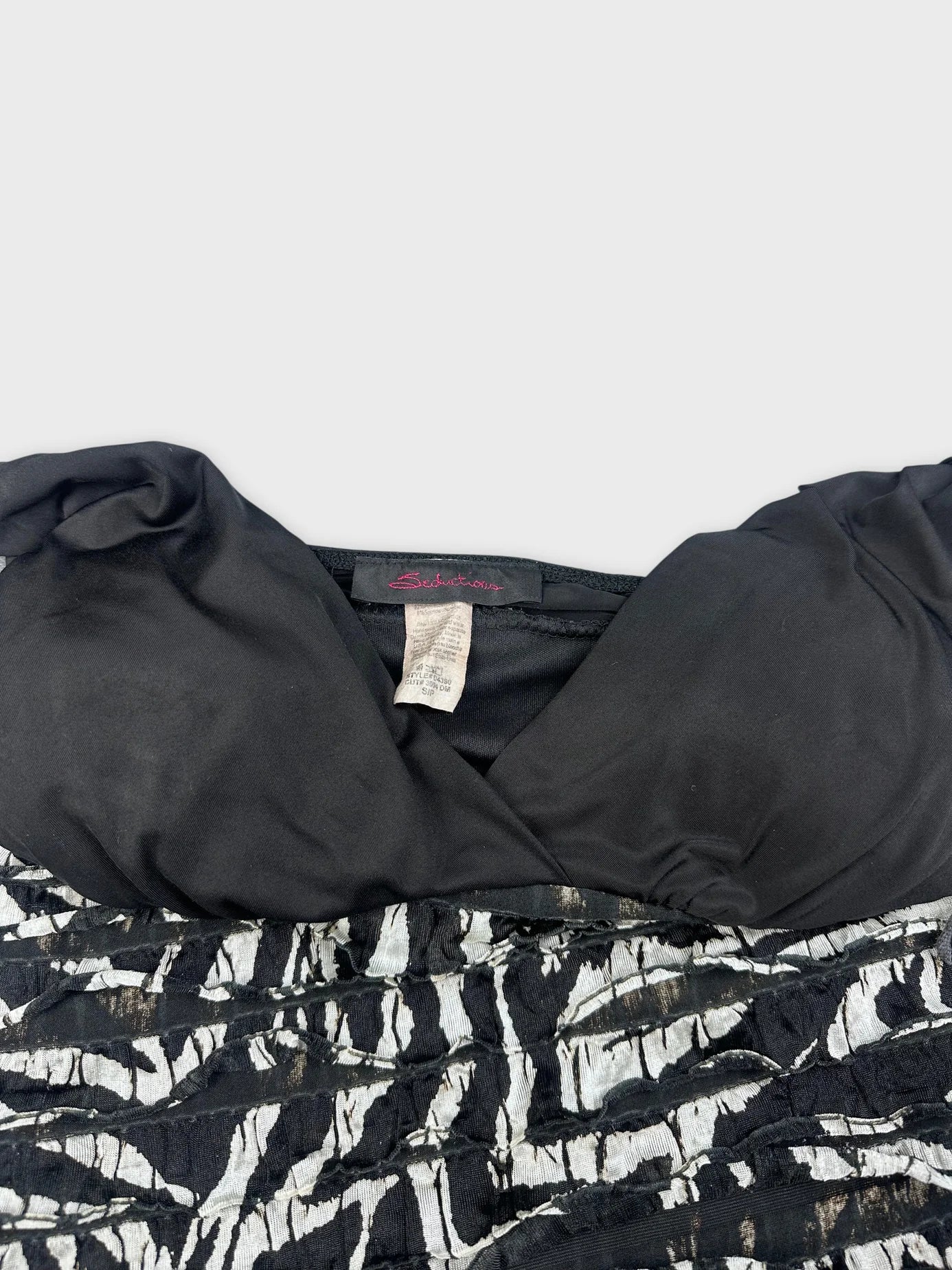 Detail view of black and white zebra striped mini dress neckline and fabric texture.