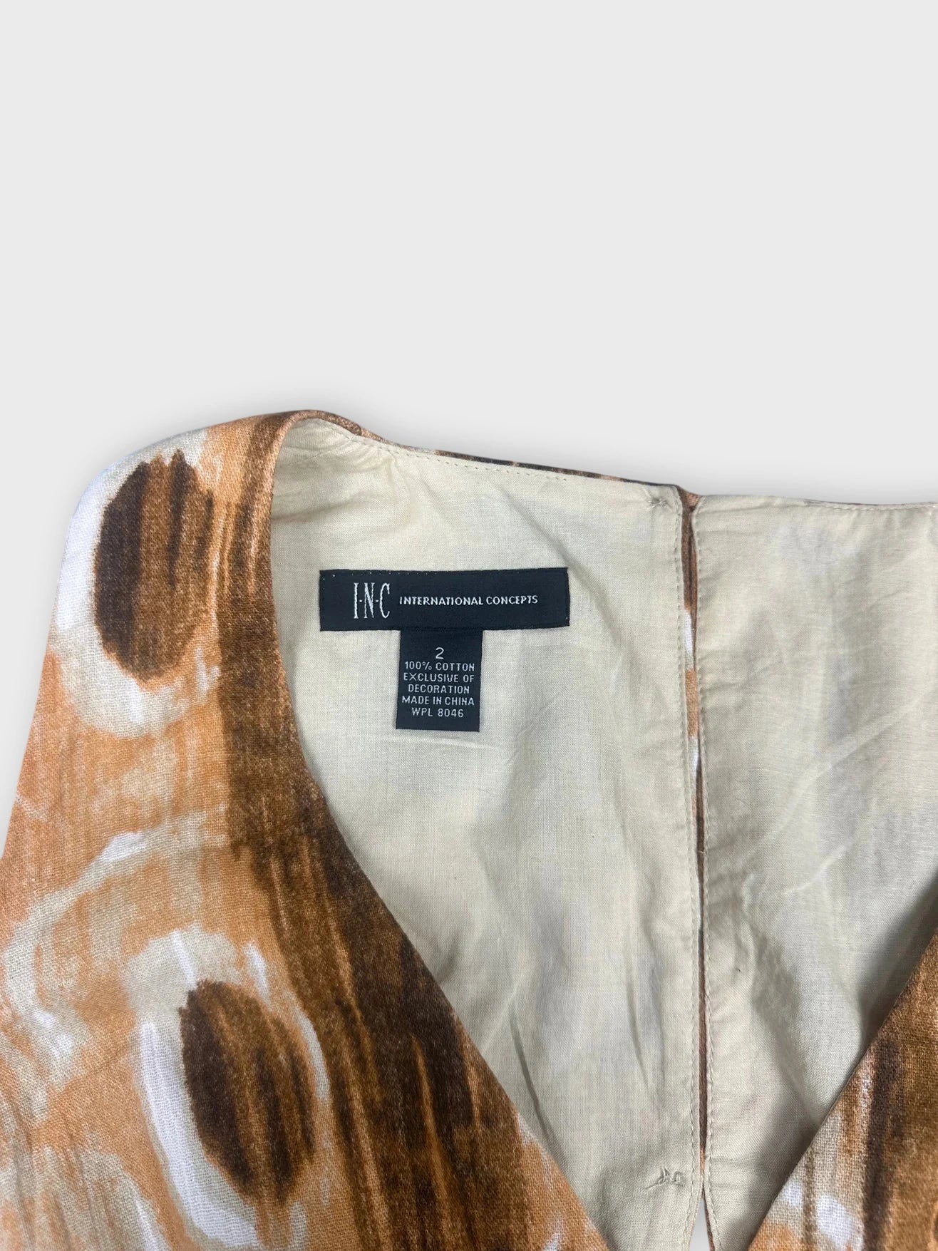 Detail view of a brown boho chic wrap top featuring lace detail.