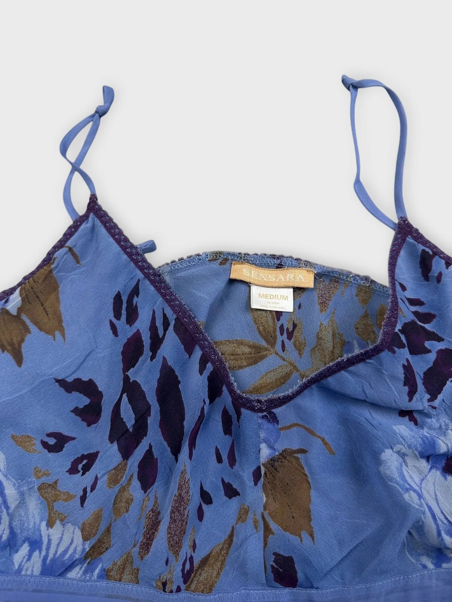 Detail view of blue floral ruffle dress with adjustable straps.