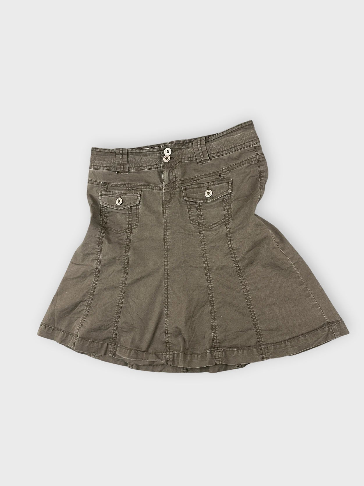 Detail view of a brown mini skirt featuring back pockets and button closure.