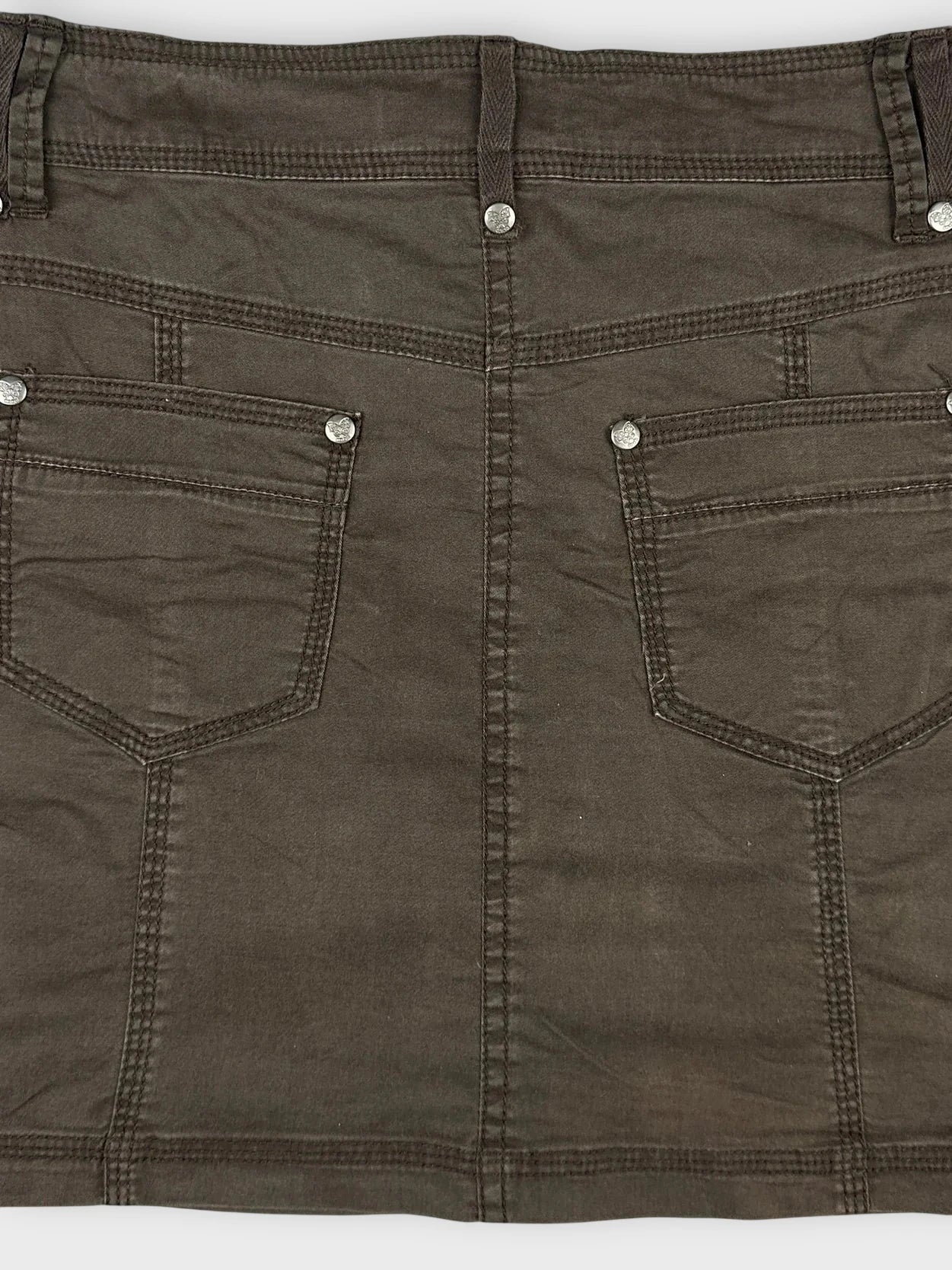 Detail view of a brown mini skirt featuring side drawstrings and two back pockets.