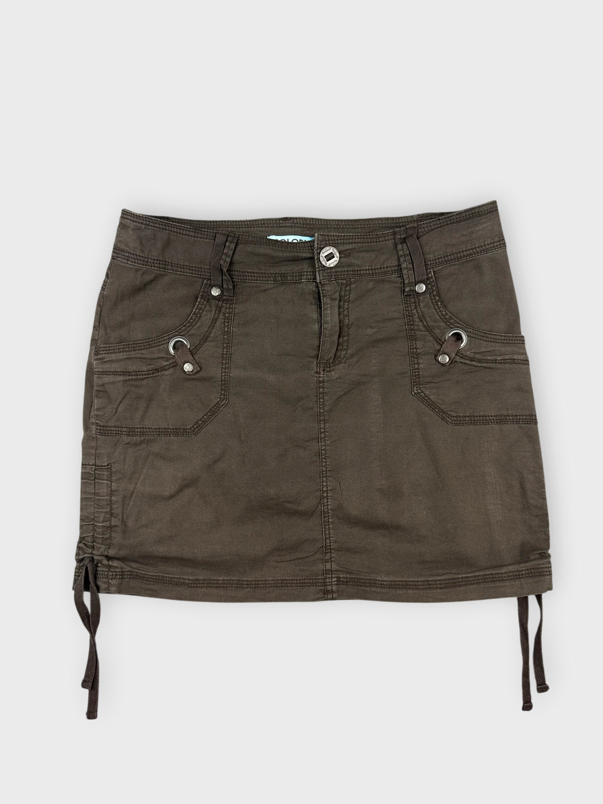Front view of a brown mini skirt with side drawstrings and pockets