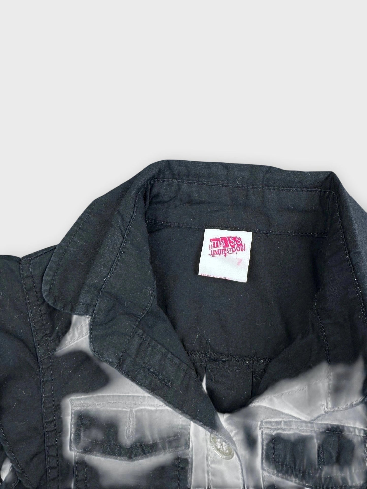 Detail view of a black button-down top featuring a classic collar.
