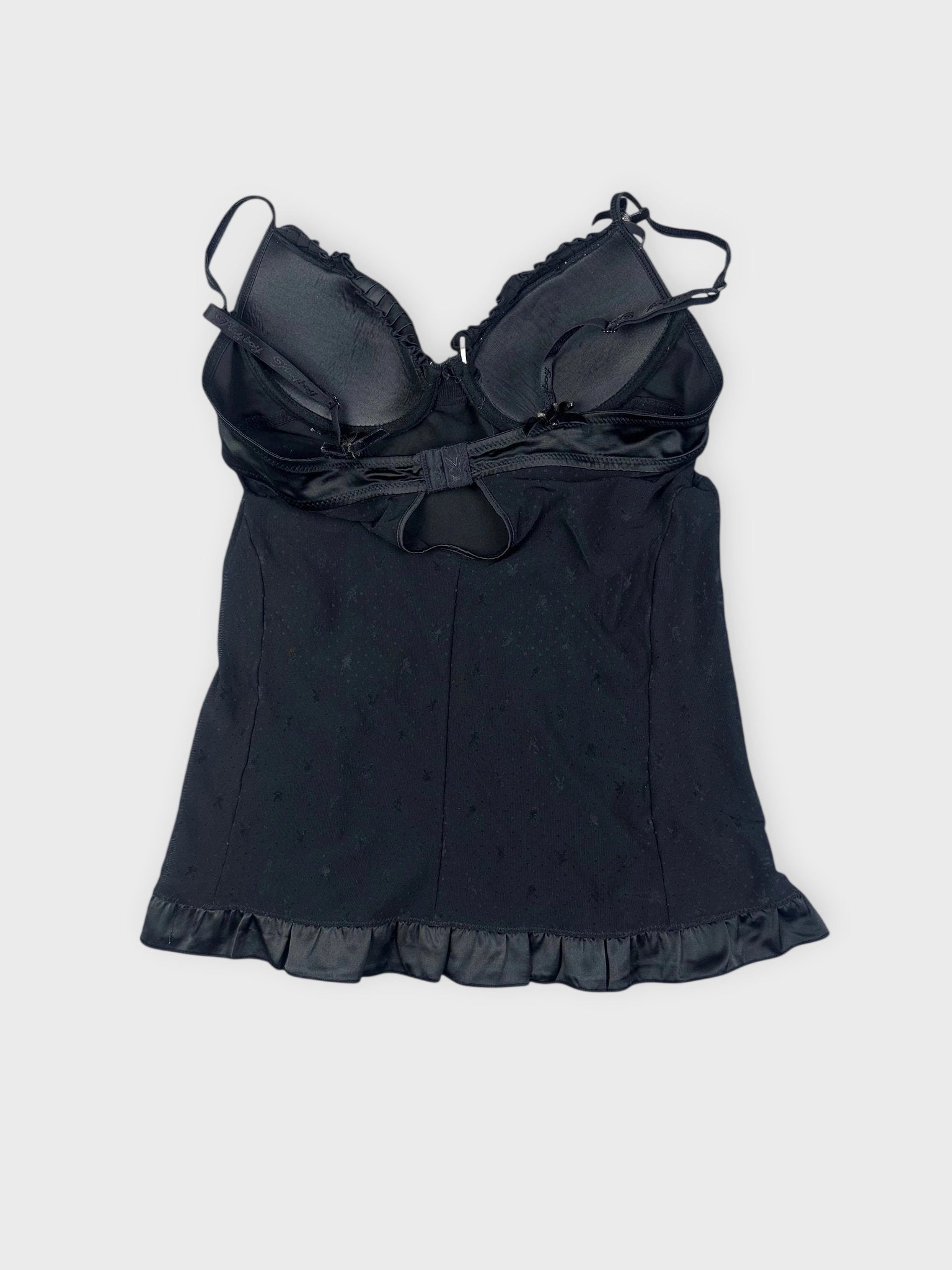 Back view of a black camisole featuring a ruffled hem.