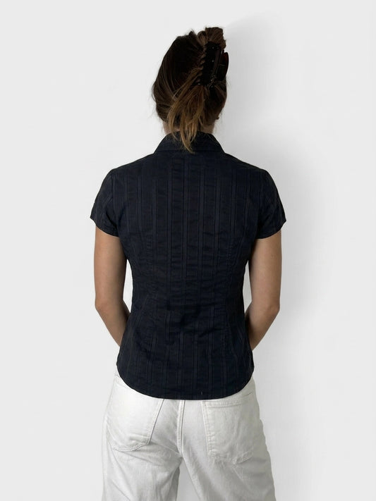 Back view of a black button-up shirt with subtle ribbed texture.