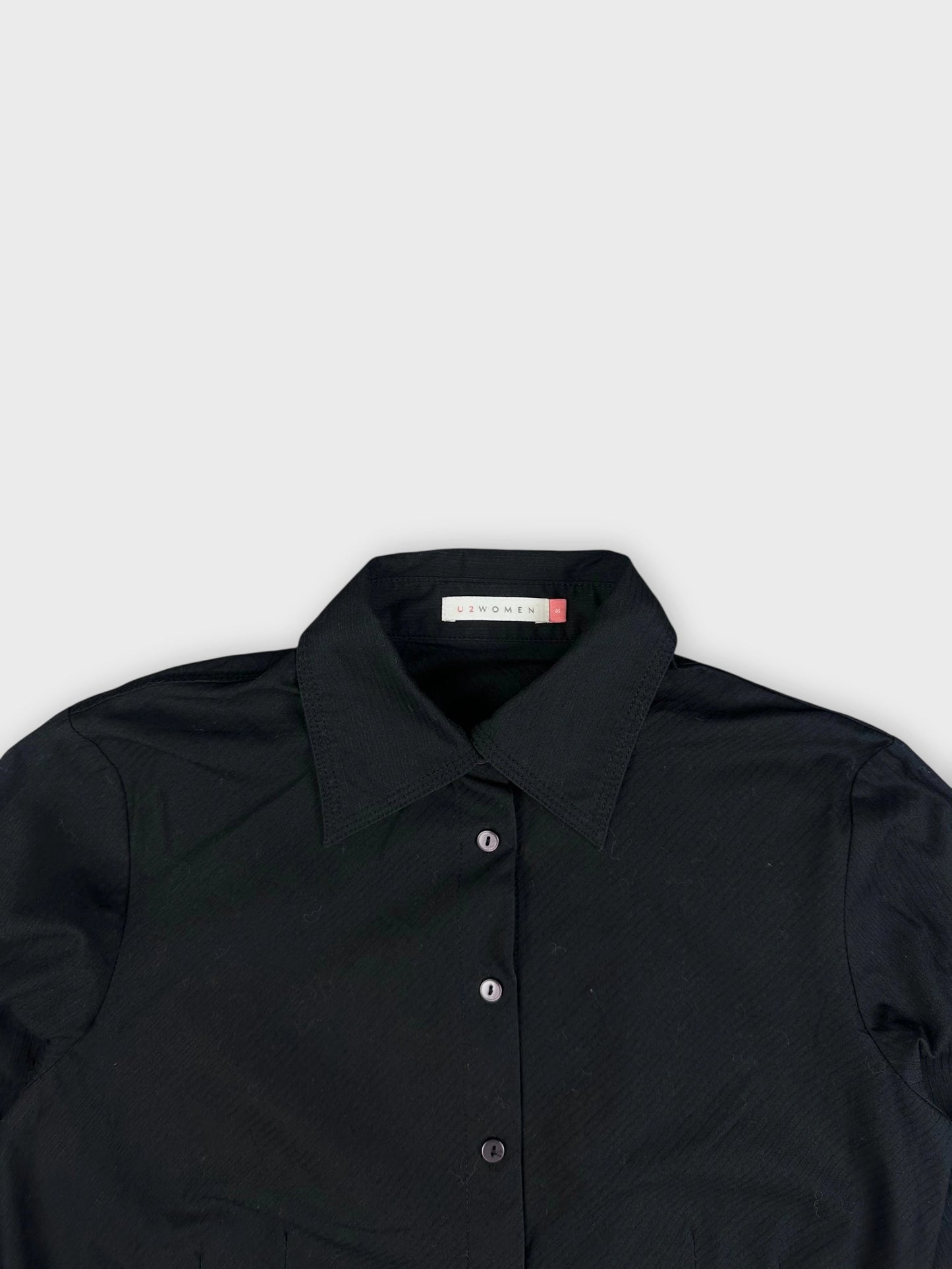 Black button-up shirt with detailed collar and front buttons detail view