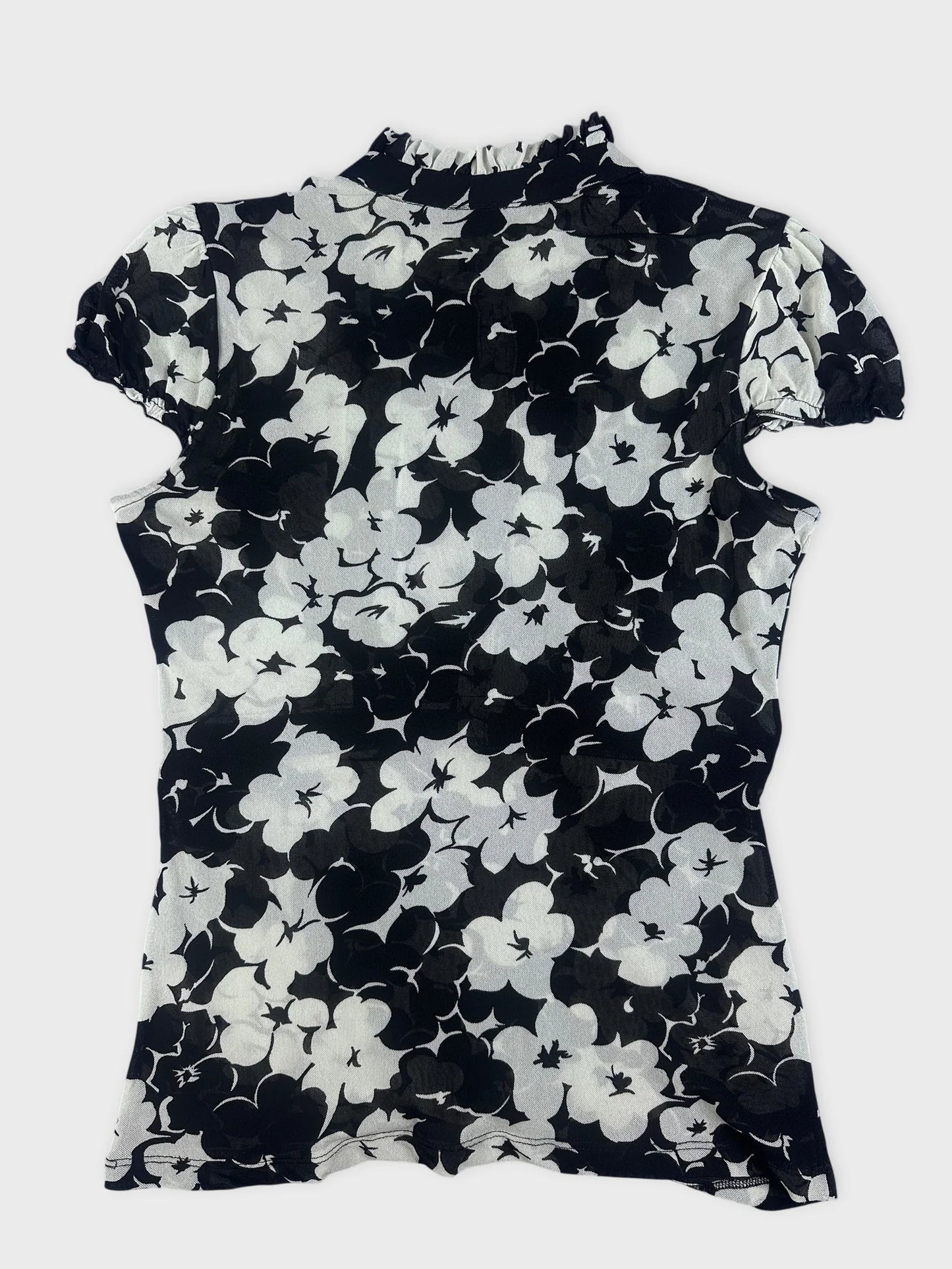 Back view of a black floral playsuit with ruffle detail.