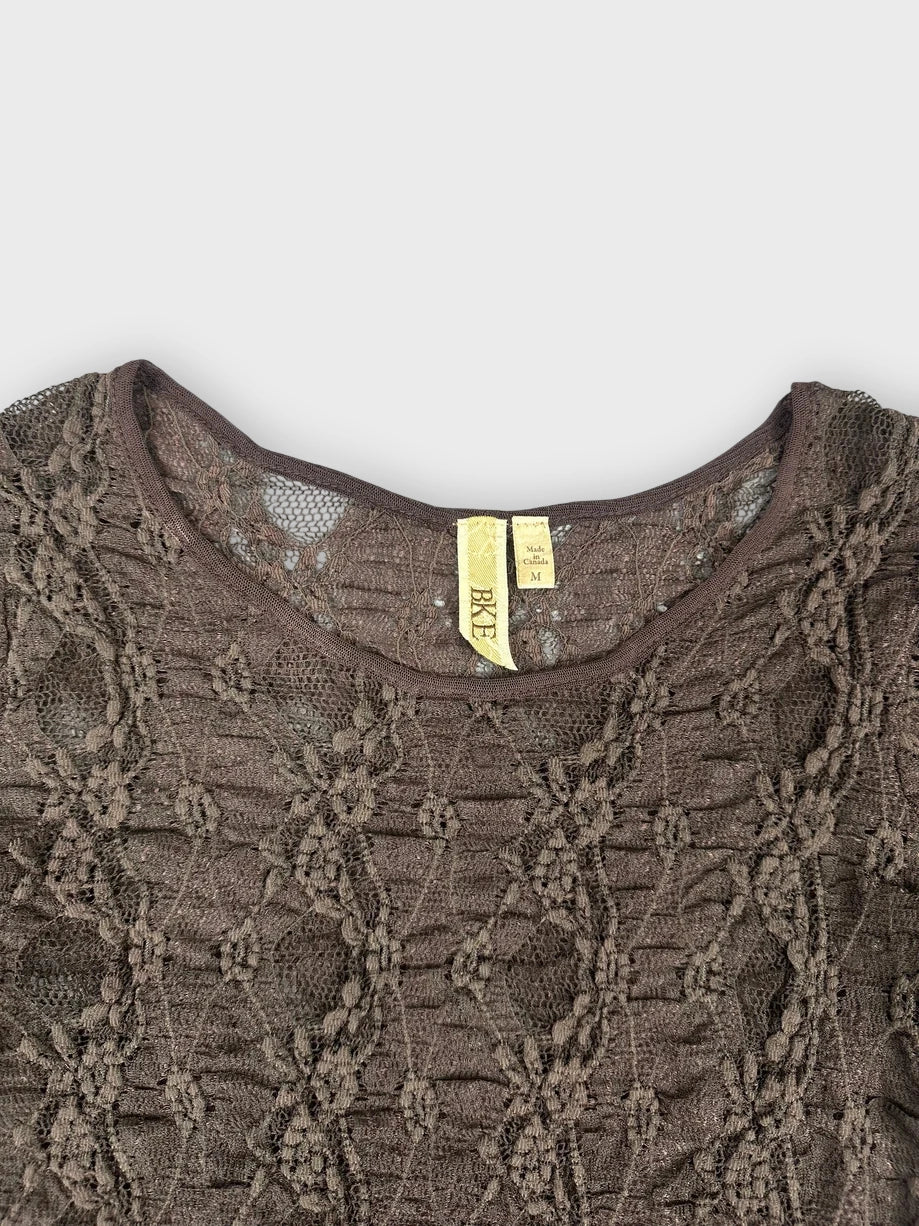 Detail view of a brown lace top featuring floral patterns and short sleeves.
