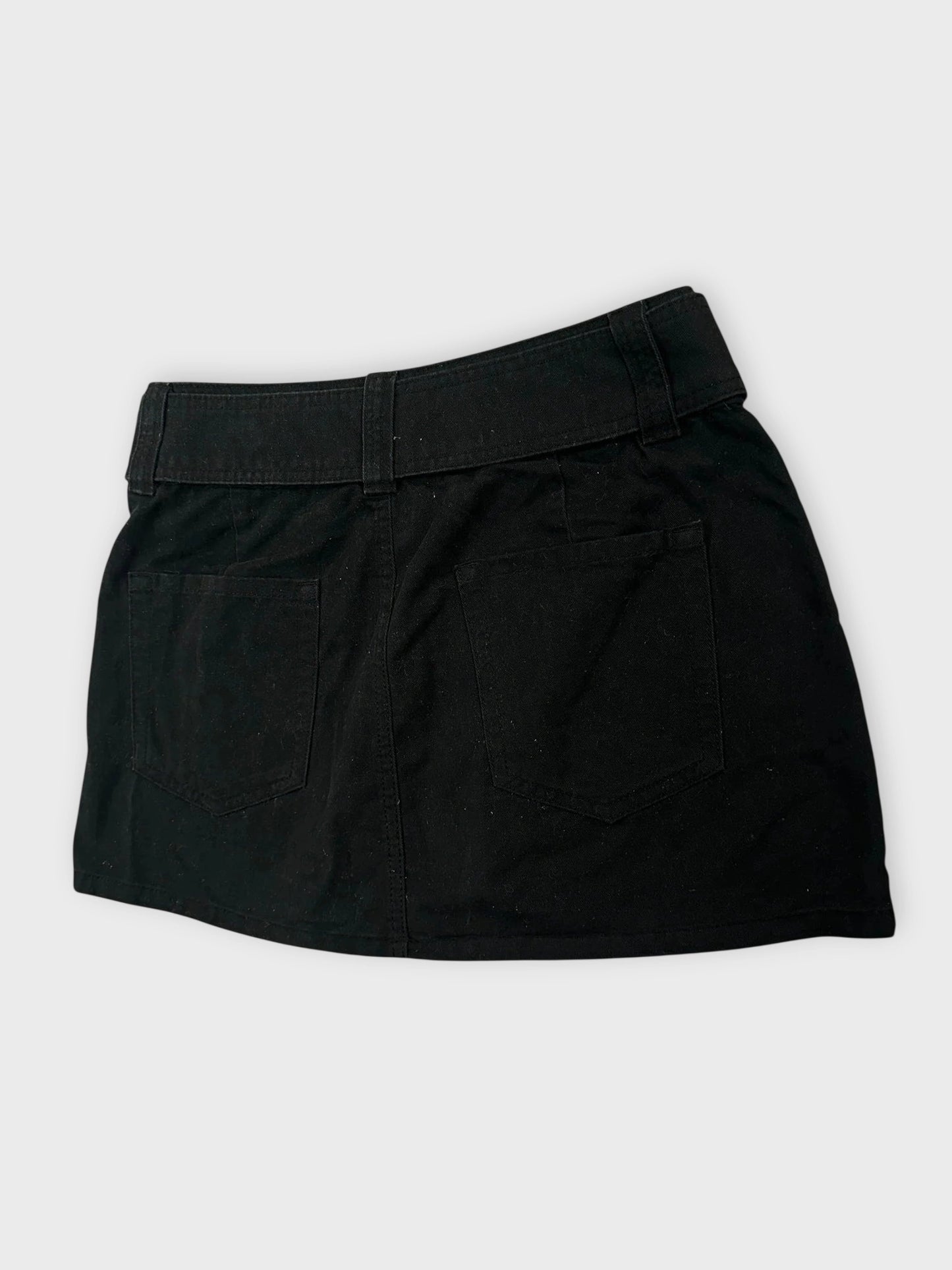 Detail view of black mini skirt with adjustable belt and back pockets.