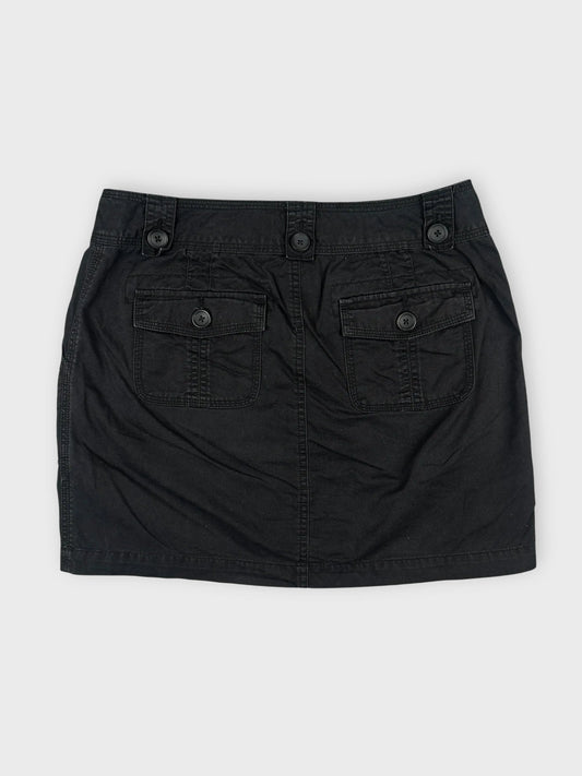 Back view of a black mini skirt featuring button details and two pockets.