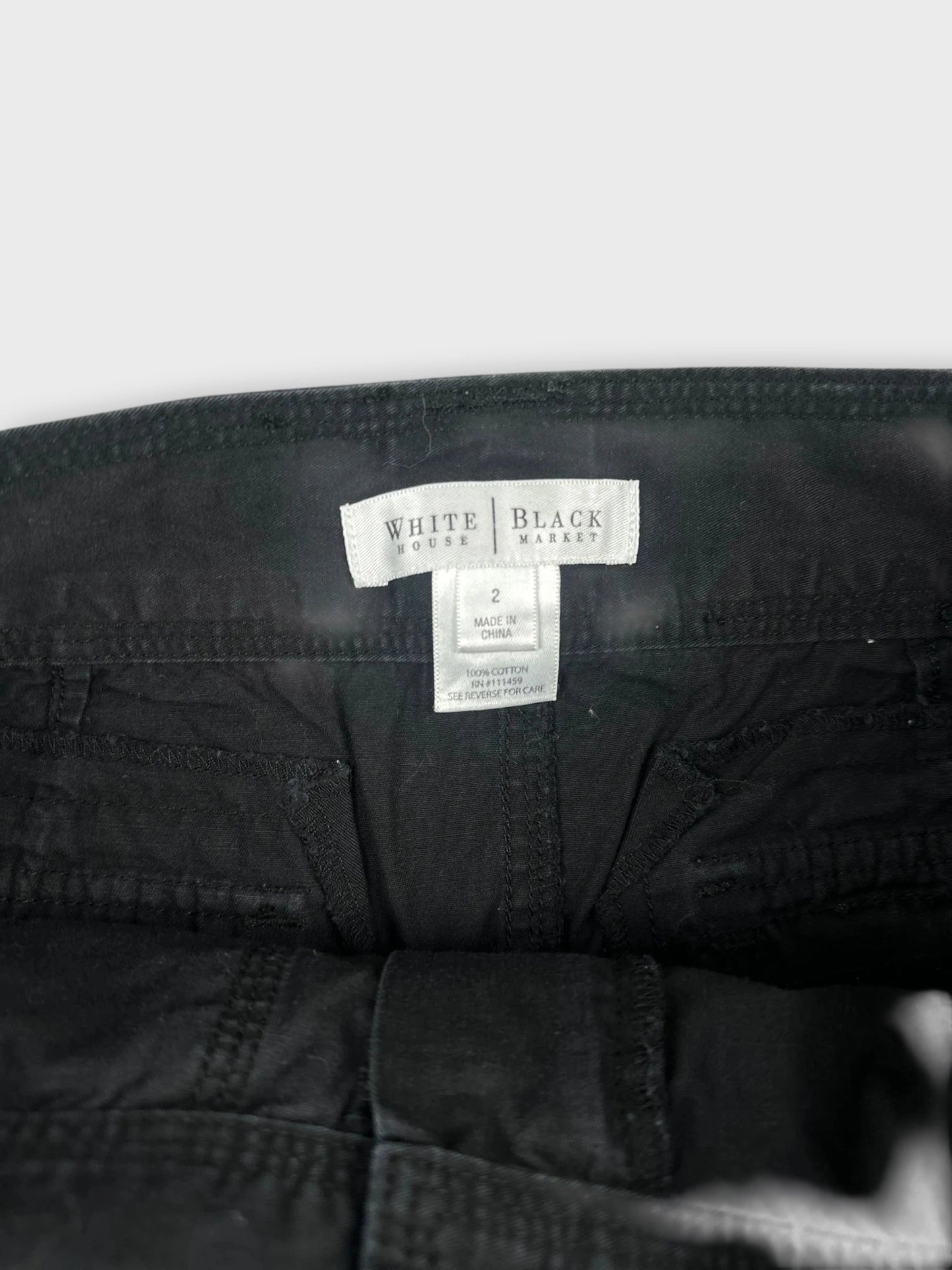 Detail view of a chic black mini skirt with button details.