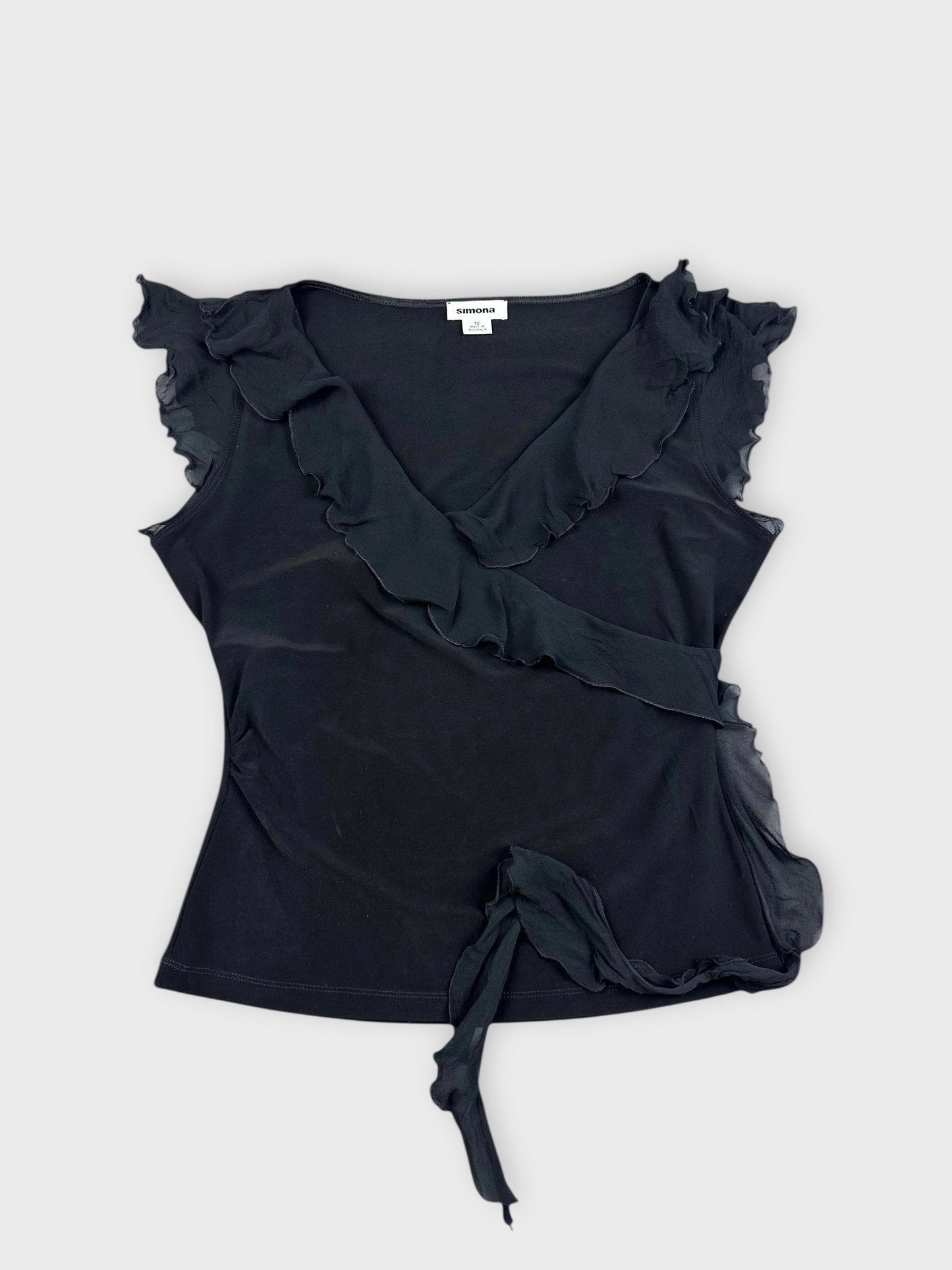Detail view of a black ruffle wrap top featuring ruffled sleeves and deep V-neck.