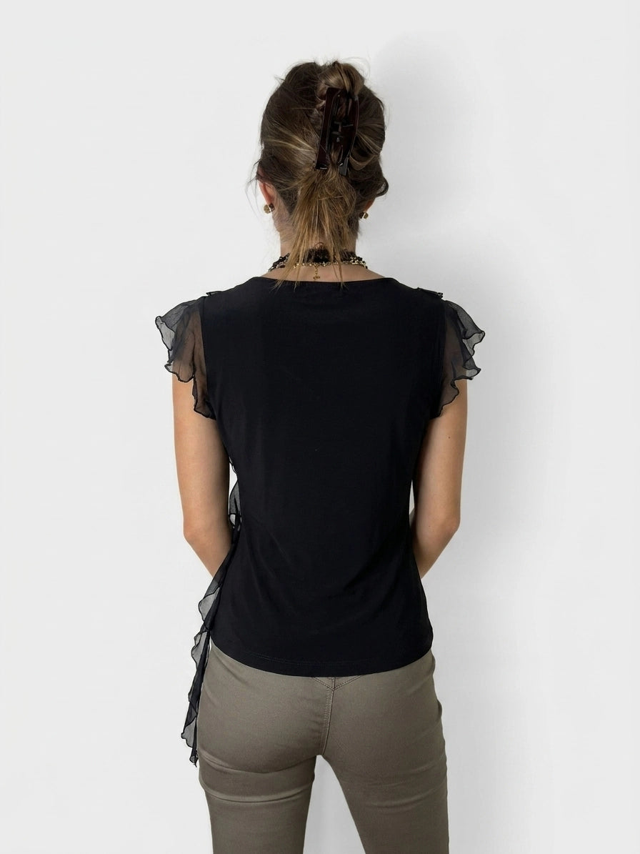 Back view of a black ruffle wrap top with sheer sleeves.